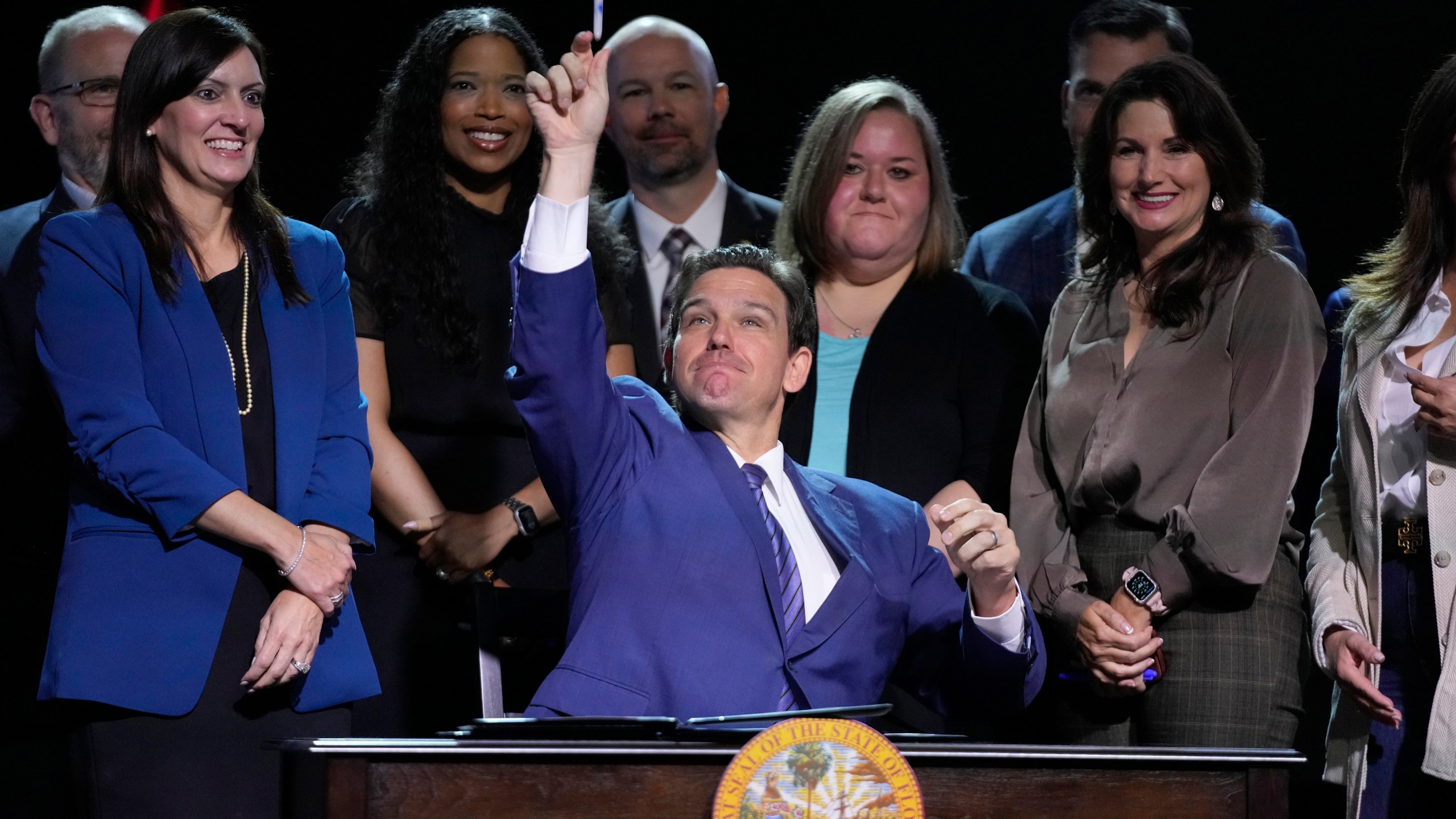 Florida Gov. Ron DeSantis throws a marker into the audience after signing various bills during a bill signing ceremony at the Coastal Community Church at Lighthouse Point, Tuesday, May 16, 2023, in Lighthouse Point, Fla. (AP Photo/Wilfredo Lee)