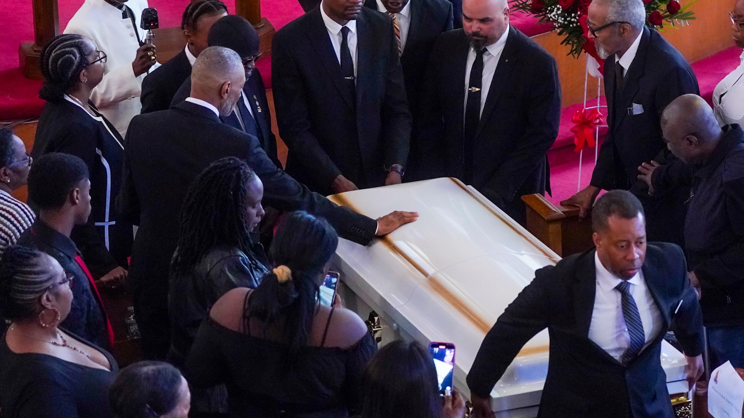 Andre Zachery, father of Jordan Neely places his hand on Neely's casket, after a funeral service at Harlem's Mount Neboh Baptist Church, Friday May 19, 2023, in New York. Neely, a former Michael Jackson impersonator who had been struggling with mental illness and homelessness in recent years, died May 1 when a fellow subway rider pinned him to the floor of a subway car in a chokehold that lasted several minutes. (AP Photo/Bebeto Matthews)