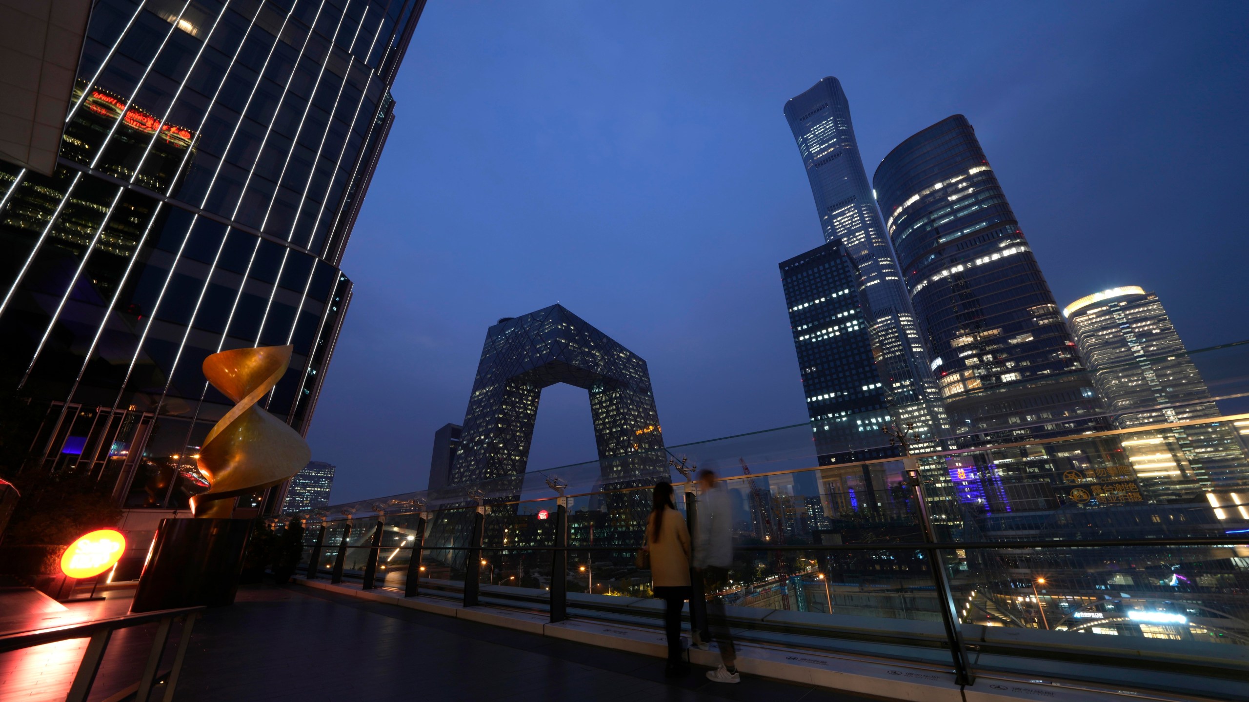 File - People linger in the Central Business District in Beijing, Wednesday, Oct. 26, 2022. If the debt crisis now roiling Washington were eventually to send the United States crashing into recession, the repercussions of a first-ever default on the federal debt would reverberate around the world and quickly. (AP Photo/Ng Han Guan, File)