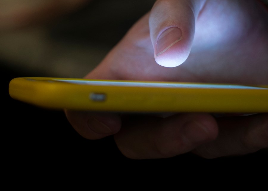 FILE - A man uses a cellphone in New Orleans, Aug. 11, 2019. On Tuesday, May 23, 2023, attorneys general across the U.S. joined in a lawsuit against a telecommunications company accused of making more than 7.5 billion robocalls to people on the national Do Not Call Registry. (AP Photo/Jenny Kane, File)