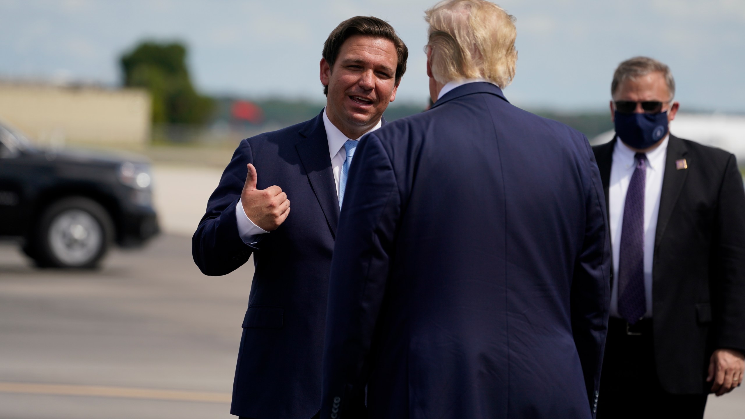 FILE - President Donald Trump speaks with Florida Gov. Ron DeSantis as he arrives at Southwest Florida International Airport, Oct. 16, 2020, in Fort Myers, Fla. (AP Photo/Evan Vucci, File)