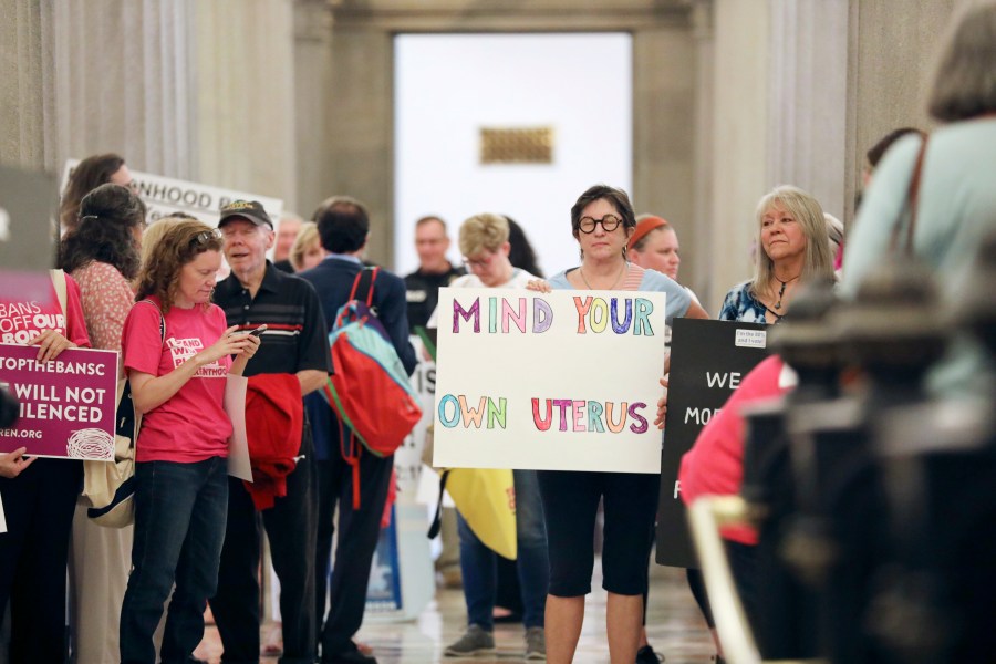 Protesters against a stricter ban on abortion in South Carolina stand in the Statehouse lobby on Tuesday, May, 23, 2023, in Columbia, South Carolina. (AP Photo/Jeffrey Collins)