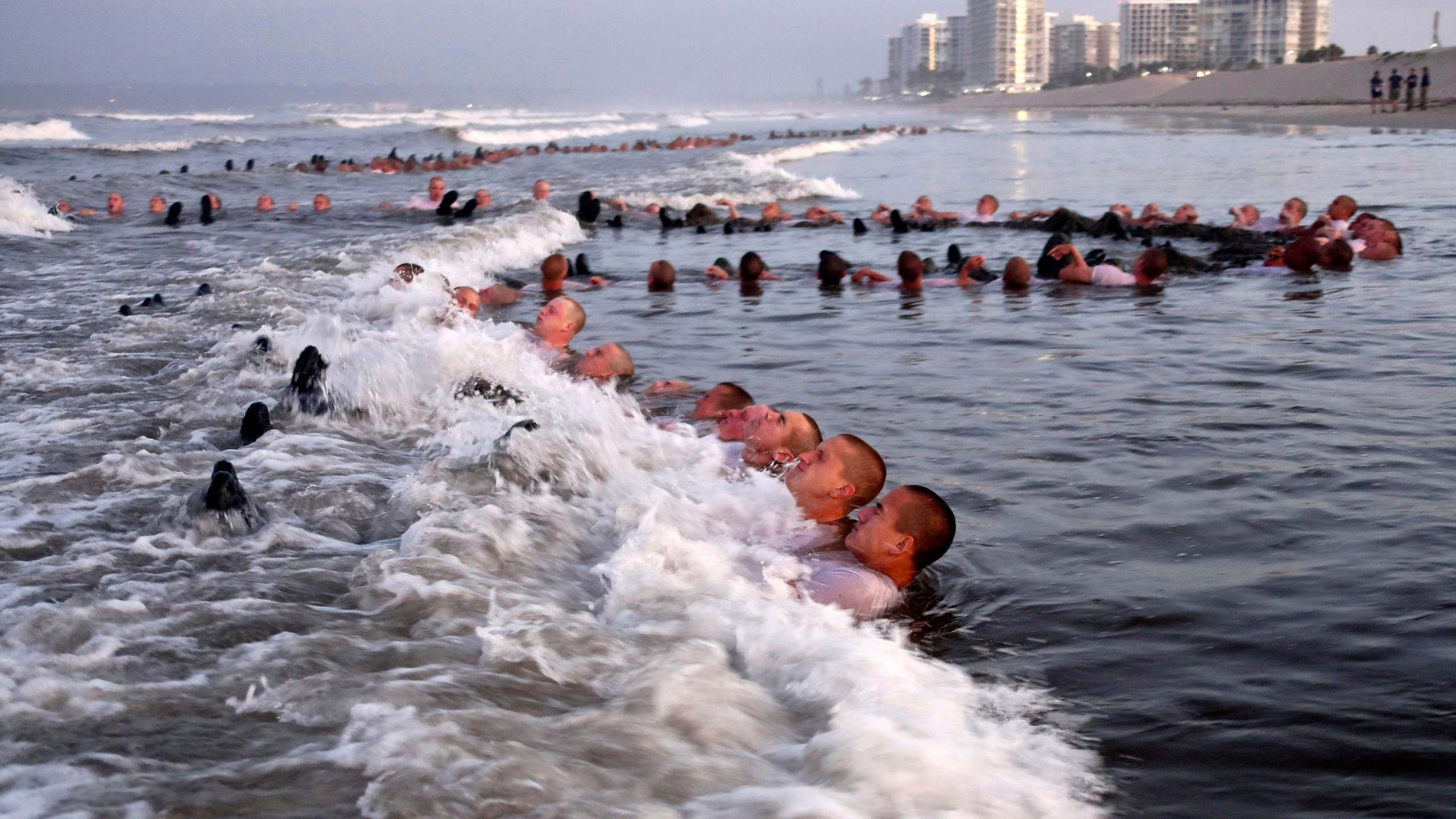 FILE - U.S. Navy SEAL candidates, participate in "surf immersion" during Basic Underwater Demolition/SEAL (BUD/S) training at the Naval Special Warfare (NSW) Center in Coronado, Calif., on May 4, 2020. The training program for Navy SEALs is plagued by widespread medical failures, poor oversight and the use of performance enhancing drugs that have increased the risk of injury and death to candidates seeking to become an elite commando, according to a highly critical new investigation triggered by the death of SEAL candidate Kyle Mullen. (MC1 Anthony Walker/U.S. Navy via AP, File)