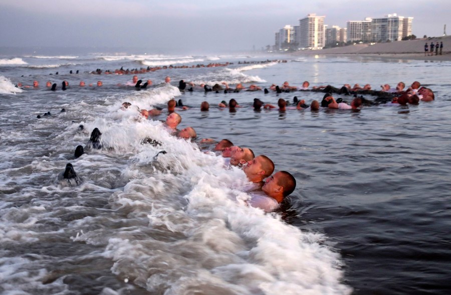 FILE - U.S. Navy SEAL candidates, participate in "surf immersion" during Basic Underwater Demolition/SEAL (BUD/S) training at the Naval Special Warfare (NSW) Center in Coronado, Calif., on May 4, 2020. The training program for Navy SEALs is plagued by widespread medical failures, poor oversight and the use of performance enhancing drugs that have increased the risk of injury and death to candidates seeking to become an elite commando, according to a highly critical new investigation triggered by the death of SEAL candidate Kyle Mullen. (MC1 Anthony Walker/U.S. Navy via AP, File)