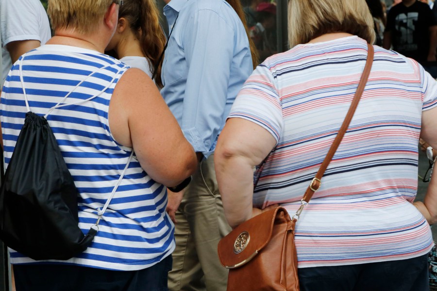 FILE — Two women stand on Aug. 16, 2016, New York. New York City Mayor Eric Adams signed a bill Friday, May 26, 2023, that will prohibit discrimination based on body size by adding weight and height to the list of protected categories like race, sex and religion. (AP Photo/Mark Lennihan, File)