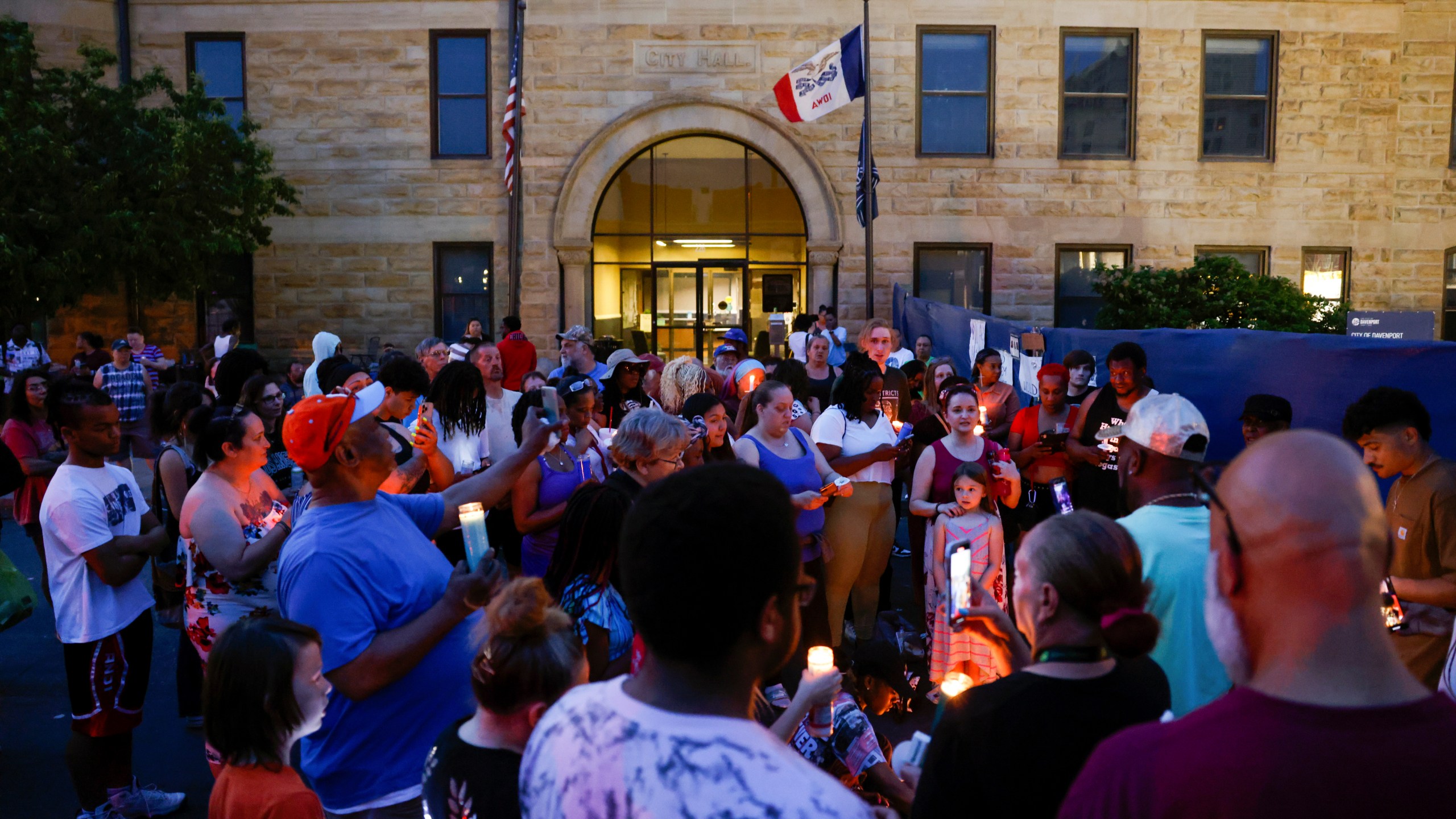 Community members gather for a candlelight vigil for Branden Colvin Sr., Ryan Hitchcock and Daniel Prien outside Davenport City Hall, Sunday, June 4, 2023, in Davenport, Iowa. The three men had been missing since the partial collapse of an apartment building on May 28. Colvin has since been confirmed to have died in the collapse. (Nikos Frazier/Quad City Times via AP)