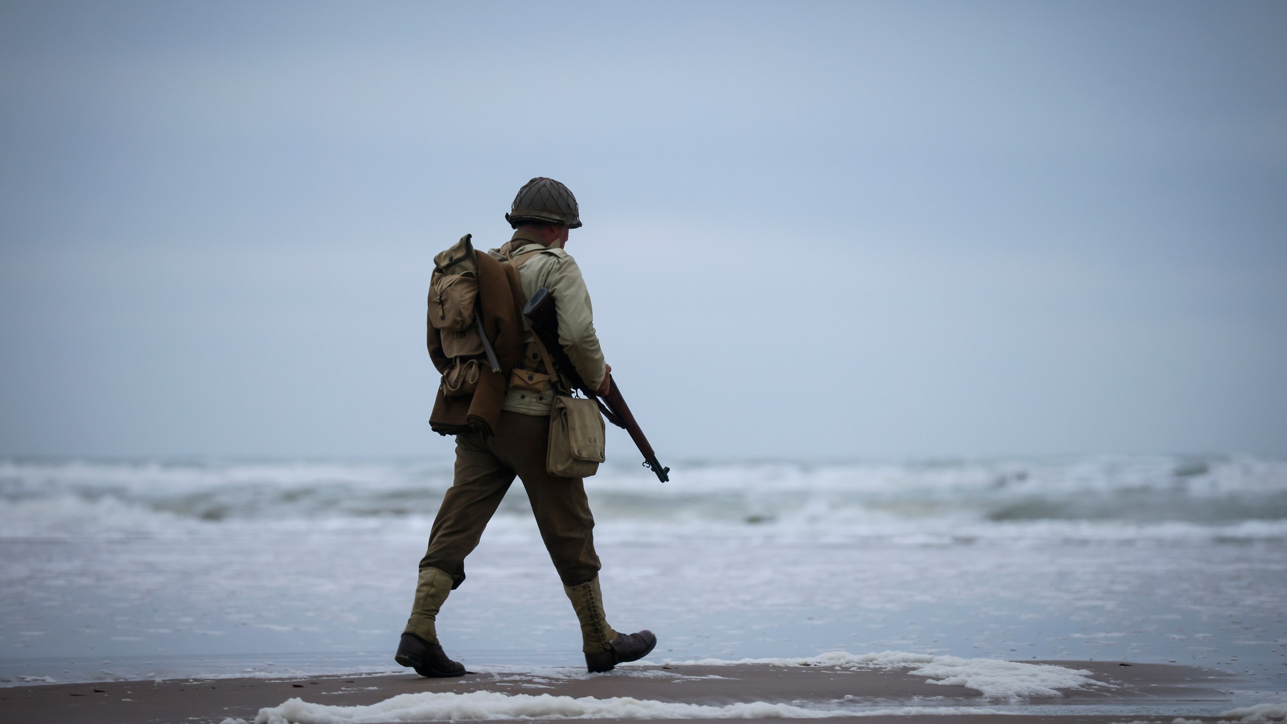 A World War II reenactor walks on Omaha Beach in Saint-Laurent-sur-Mer, Normandy, France, Tuesday, June 6, 2023. The D-Day invasion that helped change the course of World War II was unprecedented in scale and audacity. Nearly 160,000 Allied troops landed on the shores of Normandy at dawn on June 6, 1944. (AP Photo/Thomas Padilla)