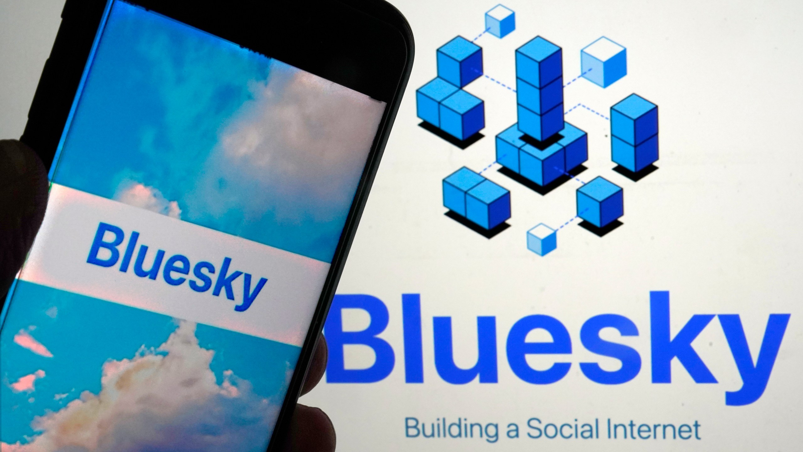 The app for Bluesky is shown on a mobile phone, left, and on a laptop screen, in New York, Friday, June 2, 2023. Bluesky, the internet's hottest members-only spot at the moment, does feel a bit like an exclusive club, populated by some Very Online folks, popular Twitter characters as well as fed up ex-users of the Elon Musk-owned platform. (AP Photo/Richard Drew)