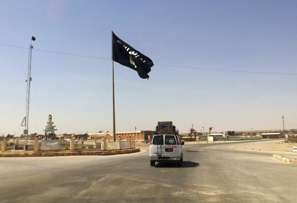 FILE - A vehicle passes by a flag of the Islamic State group in central Rawah, 175 miles (281 kilometers) northwest of Baghdad, Iraq. U.N. investigators are compiling evidence on the development and use of chemical weapons by Islamic State extremists in Iraq after they seized about a third of the country in 2014, and are advancing work on the militant group’s gender-based violence and crimes against children, Sunni and Shiite Muslims, Christians and Yazidis, the head of the investigative team said Wednesday, June 7, 2023. (AP Photo/File)