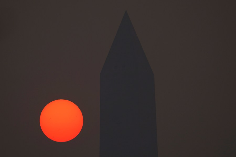 The sun rises behind the Washington Monument and a thick layer of smoke, Thursday, June 8, 2023, in Washington. Intense Canadian wildfires are blanketing the northeastern U.S. in a dystopian haze, turning the air acrid, the sky yellowish gray and prompting warnings for vulnerable populations to stay inside. (AP Photo/Julio Cortez)