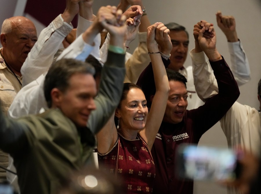 Ruling MORENA party presumptive presidential candidate and Mexico City's Mayor Claudia Sheinbaum, center, raises her arms during a news conference at a hotel in Mexico City, Sunday, June 11, 2023. President Andres Manuel Lopez Obrador's MORENA party announced the rules to be followed by its candidates for the presidential elections of 2024 and the date of the primary elections to determine who will get the party's nomination. (AP Photo/Fernando Llano)