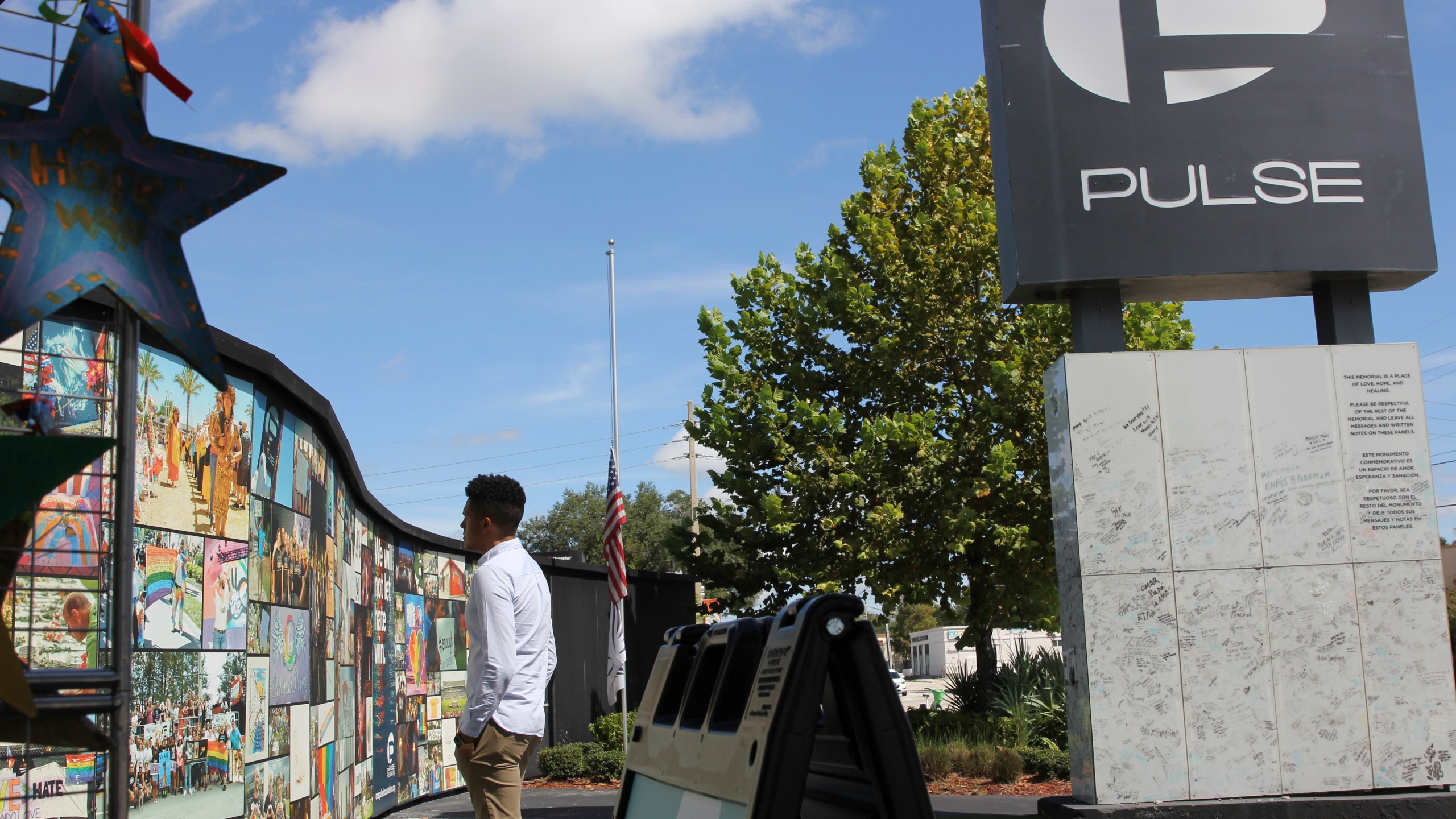 FILE - Brandon Wolf, a survivor of the Pulse nightclub shooting and activist, looks at the photos that are a part of the Pulse memorial in Orlando, Fla., on Sept. 9, 2022. Across central Florida, the 49 victims killed and dozens more survivors of the massacre at a gay-friendly nightclub were remembered with the unveiling of a 44-foot (13.4-meter) wide mural and an overnight vigil at the site of the Pulse club on the seventh anniversary of the tragedy. Several people gathered at the site of the Pulse nightclub at 2 a.m. Monday, June 12, 2023 around the time the tragedy occurred. (AP Photo/Cody Jackson, file)