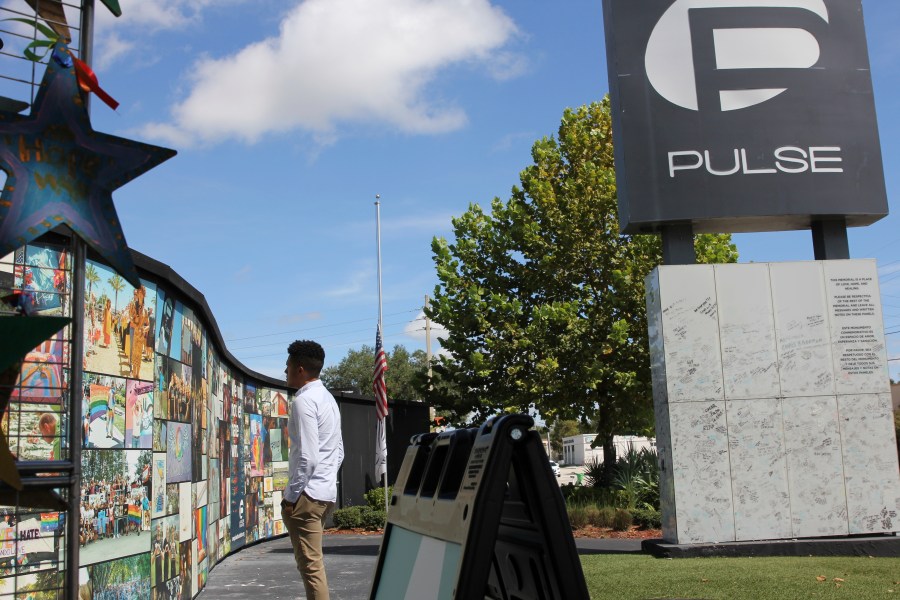 FILE - Brandon Wolf, a survivor of the Pulse nightclub shooting and activist, looks at the photos that are a part of the Pulse memorial in Orlando, Fla., on Sept. 9, 2022. Across central Florida, the 49 victims killed and dozens more survivors of the massacre at a gay-friendly nightclub were remembered with the unveiling of a 44-foot (13.4-meter) wide mural and an overnight vigil at the site of the Pulse club on the seventh anniversary of the tragedy. Several people gathered at the site of the Pulse nightclub at 2 a.m. Monday, June 12, 2023 around the time the tragedy occurred. (AP Photo/Cody Jackson, file)