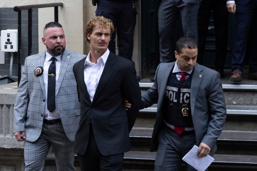 FILE - Daniel Penny, center, is walked by New York Police Department detectives out of the 5th Precinct, May 12, 2023, in New York. Penny, the man charged with manslaughter for putting an agitated New York City subway rider in a fatal chokehold, has been indicted by a grand jury, an expected procedural step that will allow the criminal case to continue. (AP Photo/Jeenah Moon, File)