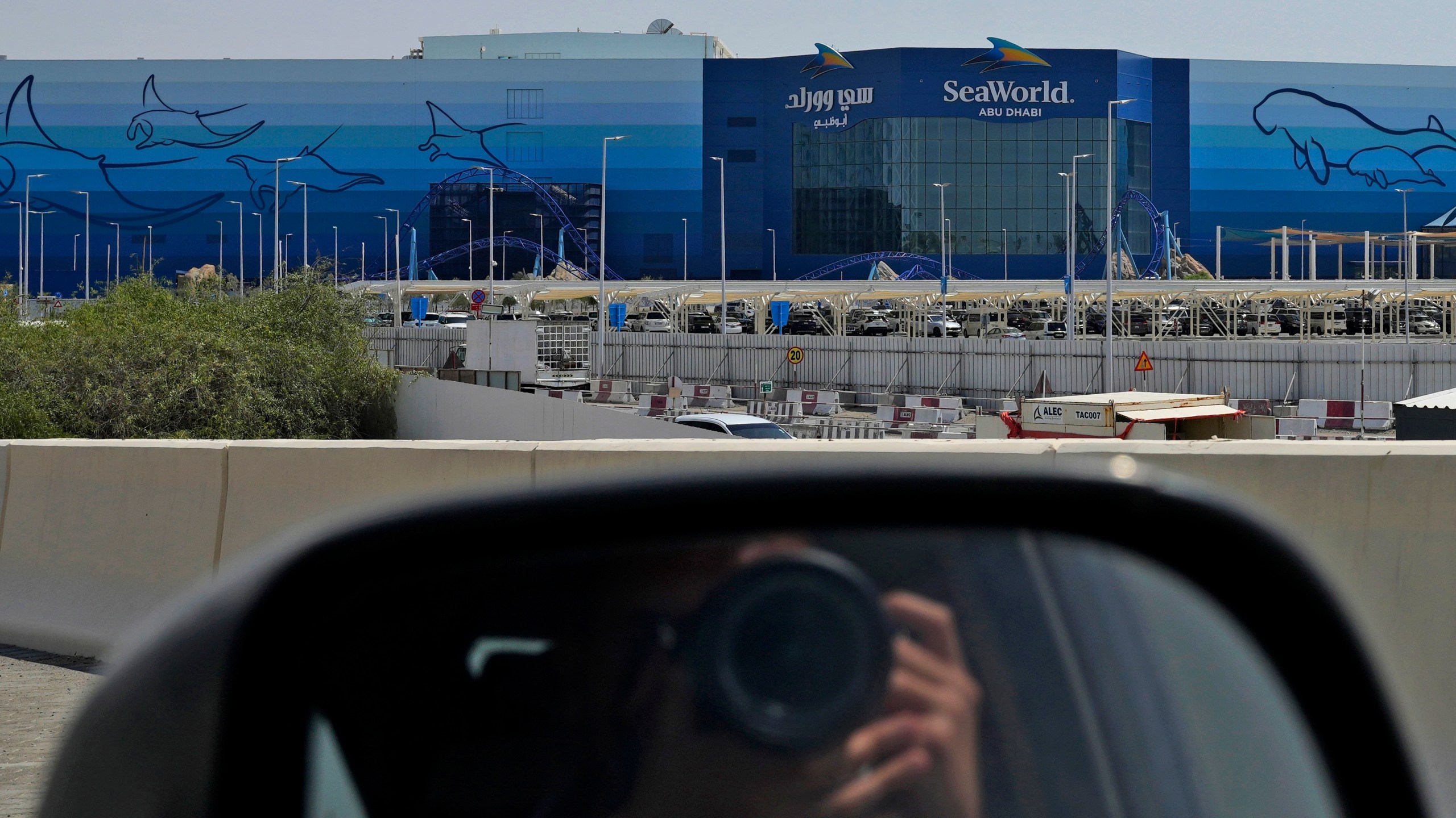 A photographer takes a picture of SeaWorld at the Yas Island in Abu Dhabi, United Arab Emirates, on May 26, 2023. It’s the first venture outside the United States for the theme park chain, which had been mired in controversy in recent years over the treatment of captive killer whales. The $1.2 billion Abu Dhabi venture with state-owned developer Miral features the world's largest aquarium and cylindrical LED screen, as well as state-of-the-art facilities housing dolphins, seals, and other animals. (AP Photo/Nick ElHajj)