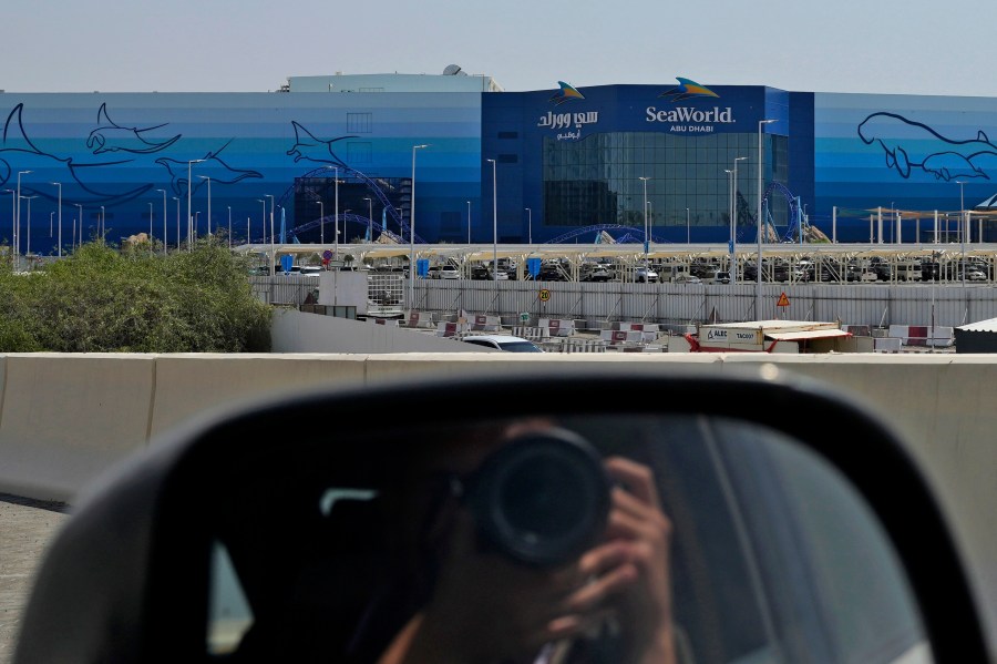 A photographer takes a picture of SeaWorld at the Yas Island in Abu Dhabi, United Arab Emirates, on May 26, 2023. It’s the first venture outside the United States for the theme park chain, which had been mired in controversy in recent years over the treatment of captive killer whales. The $1.2 billion Abu Dhabi venture with state-owned developer Miral features the world's largest aquarium and cylindrical LED screen, as well as state-of-the-art facilities housing dolphins, seals, and other animals. (AP Photo/Nick ElHajj)