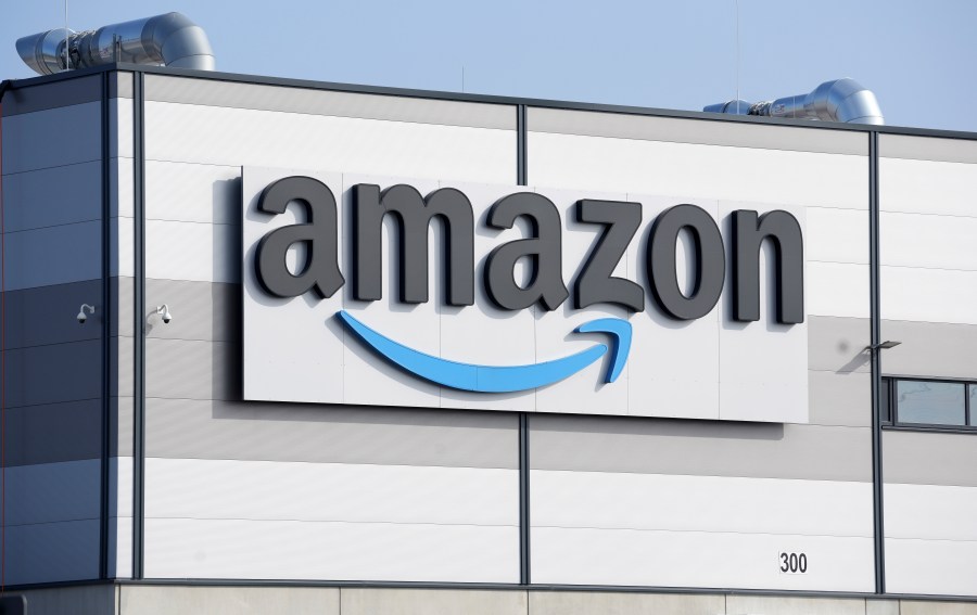 FILE - An Amazon company logo is seen on the facade of a company's building in Schoenefeld near Berlin, Germany, on March 18, 2022. British antitrust regulators have cleared Amazon’s purchase of robot vacuum maker iRobot. They gave the green light to the $1.7 billion deal on Friday, June 16, 2023, even as it still faces scrutiny in the United States and Europe. (AP Photo/Michael Sohn, File)