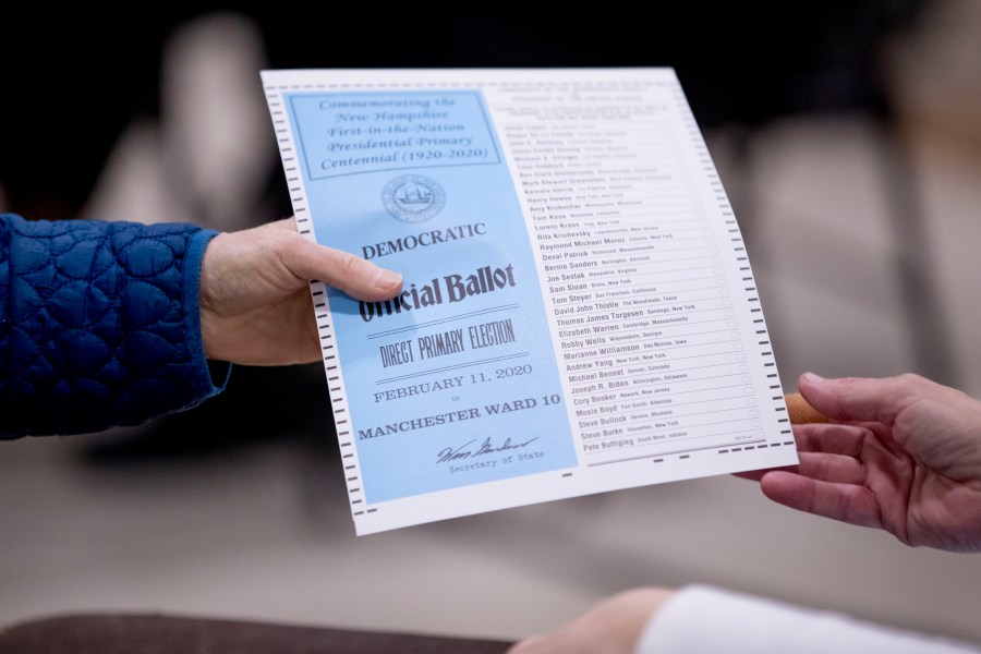 FILE - A woman takes a Democratic ballot to vote in the New Hampshire Primary at Parker-Varney Elementary School, Tuesday, Feb. 11, 2020, in Manchester, N.H. President Joe Biden's plan to overhaul his party's 2024 presidential primary schedule remained unsettled on Friday, June 16, 2023, after a Democratic rules committee gave New Hampshire more time to comply with new rules that leaders there fiercely oppose, but opted not to immediately offer such an extension to another battleground state, Georgia. (AP Photo/Andrew Harnik, File)