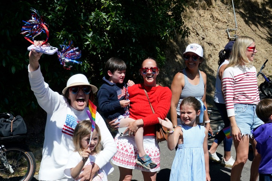 People hold signs as the motorcade with President Joe Biden drives through the area in Kentfield, Calif., where he will attend a campaign fundraiser. (AP Photo/Susan Walsh)