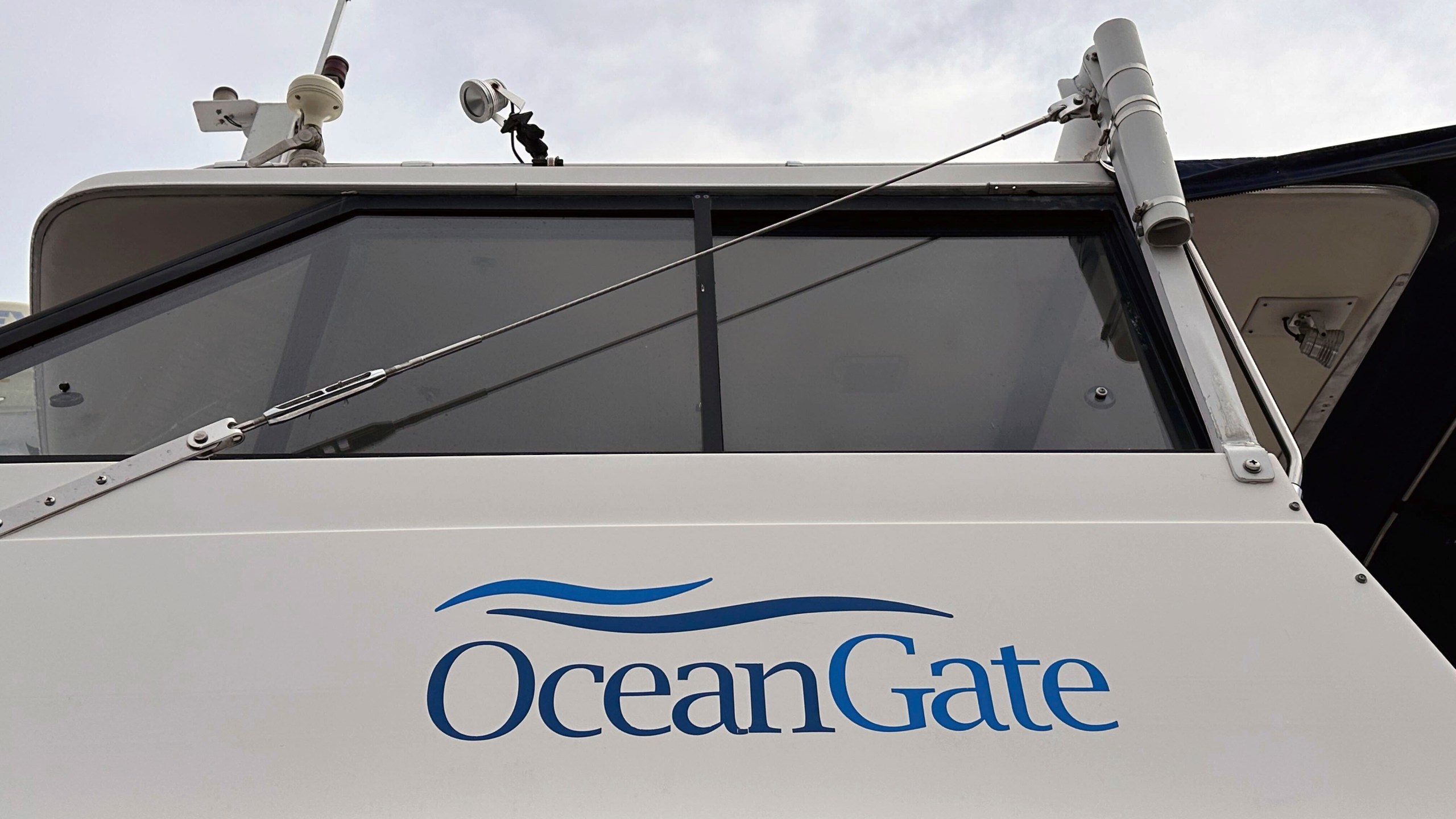 The logo for OceanGate Expeditions is seen on a boat parked near the offices of the company at a marine industrial warehouse office door in Everett, Wash., Tuesday, June 20, 2023. Rescuers raced against time to find the missing submersible carrying five people, who were reported overdue Sunday night. (AP Photo/Ed Komenda)