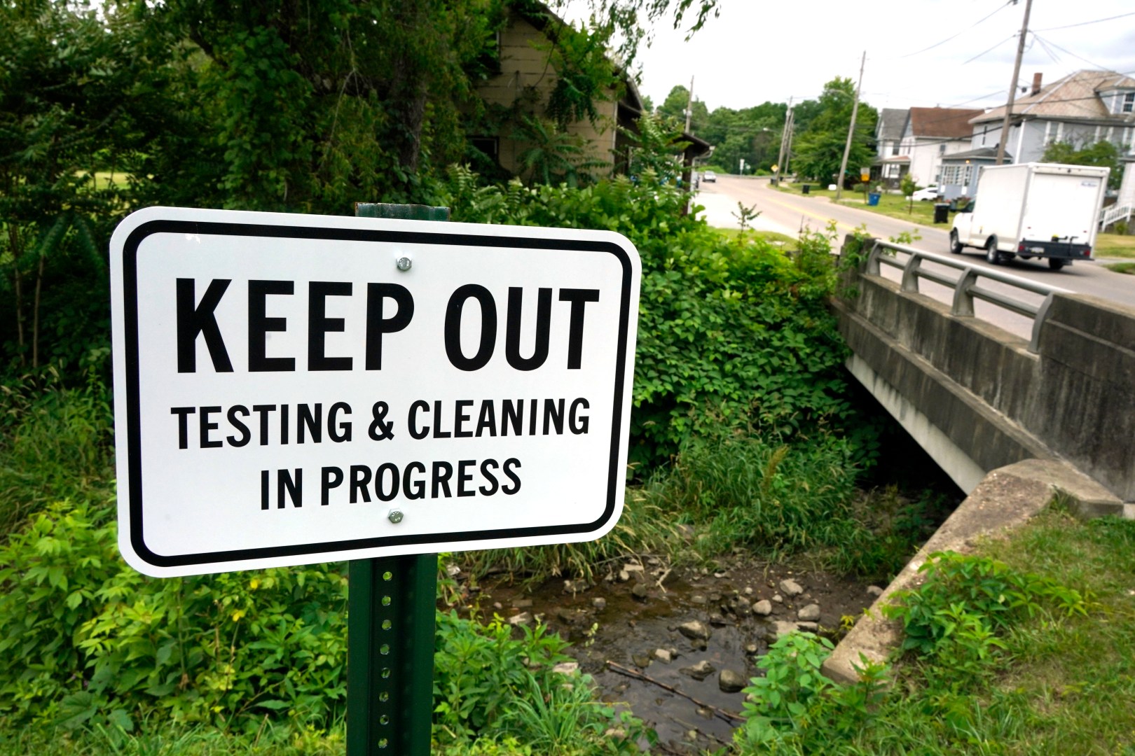 A warning sign is posted near a stream in East Palestine Park in East Palestine, Ohio on Thursday, June 22, 2023. An investigative hearing is being held by the National Transportation and Safety Board in East Palestine over two days, to investigate the Feb. 3, 2023, Norfolk Southern Railway train derailment and subsequent hazardous material release and fires. (AP Photo/Gene J. Puskar)