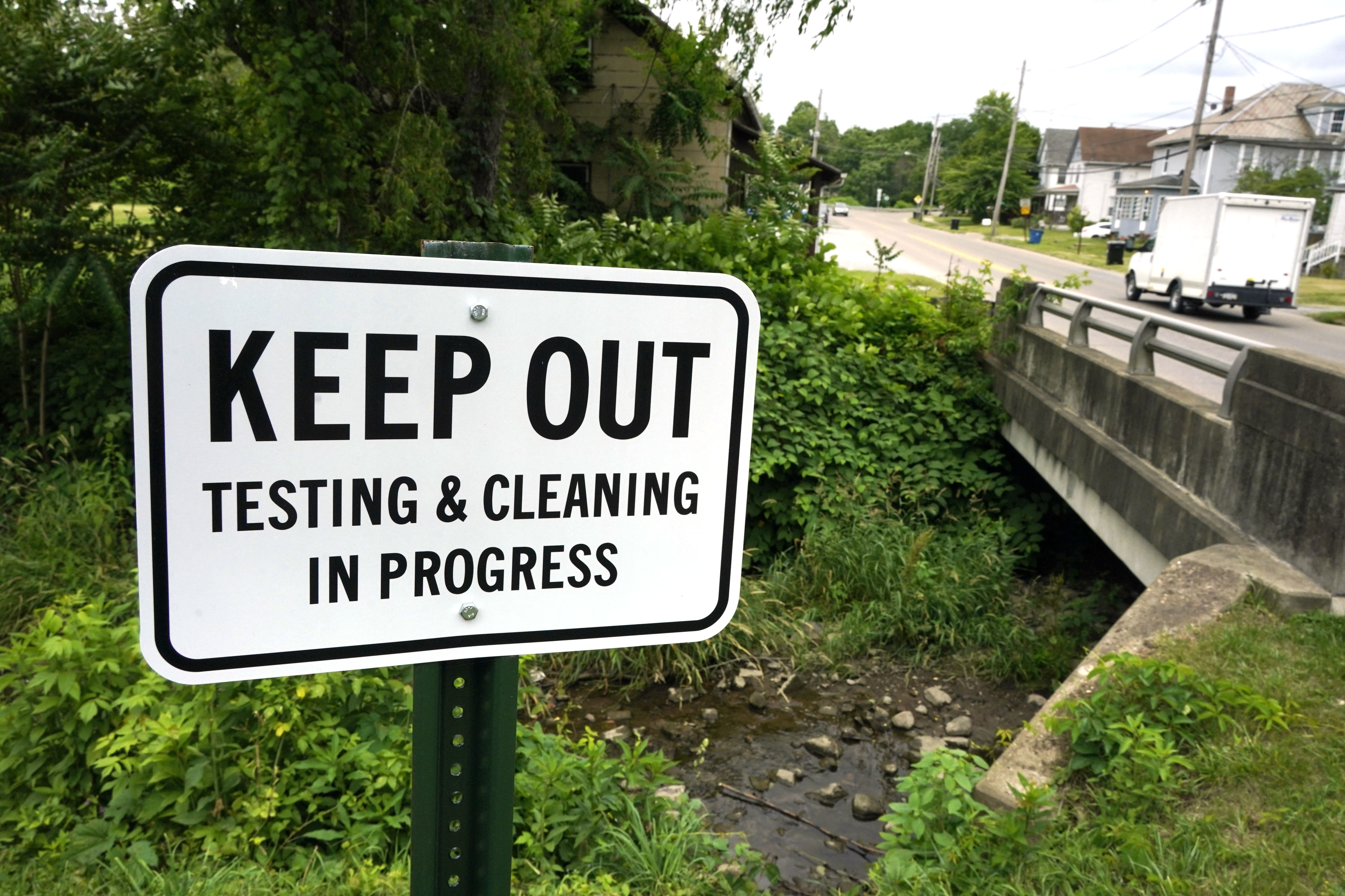 A warning sign is posted near a stream in East Palestine Park in East Palestine, Ohio on Thursday, June 22, 2023. An investigative hearing is being held by the National Transportation and Safety Board in East Palestine over two days, to investigate the Feb. 3, 2023, Norfolk Southern Railway train derailment and subsequent hazardous material release and fires. (AP Photo/Gene J. Puskar)