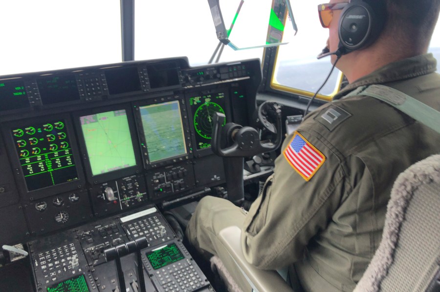 In this image provided by the U.S. Coast Guard, a crew member sits aboard a Coast Guard HC-130 Hercules airplane based at Coast Guard Air Station Elizabeth City, N.C., as it flies about 900 miles East of Cape Cod, Mass., during the search for the 21-foot submersible, Titan, Wednesday, June 21, 2023. (Petty Officer 1st Class Amber Howie/U.S. Coast Guard via AP)