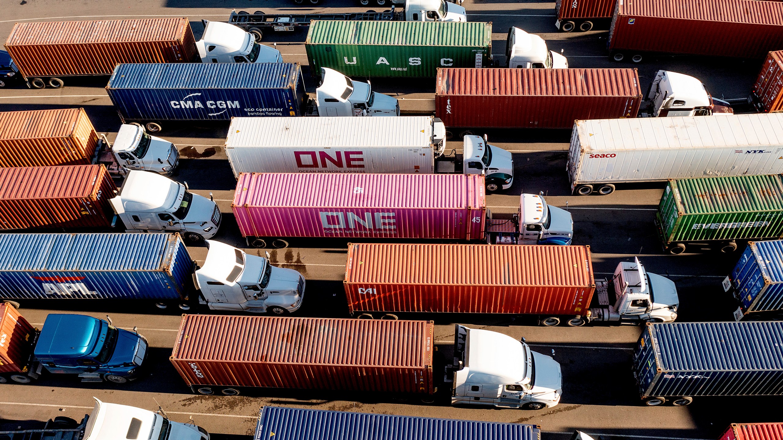 FILE - Trucks line up to enter a Port of Oakland shipping terminal on Nov. 10, 2021, in Oakland, Calif. Conservatives anxious to counter the U.S.’s leading economic adversary have set their sights on a top trade priority for labor unions and progressives: cracking down on the deluge of duty-free packages coming in from China. The changing political dynamic could have major ramifications for small businesses and consumers importing products from China valued at less than $800. (AP Photo/Noah Berger, File)