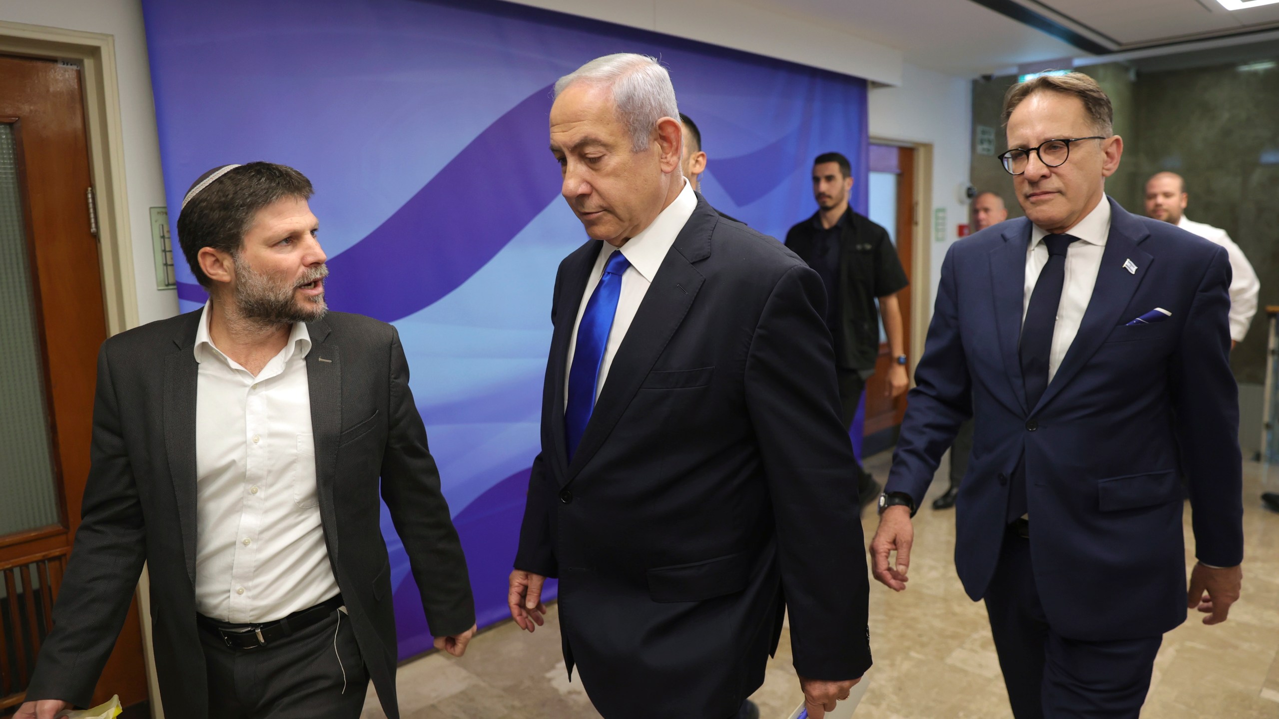 Israeli Prime Minister Benjamin Netanyahu, center, talks with Finance Minister Bezalel Smotrich, left, during the weekly cabinet meeting in the prime minister's office in Jerusalem, Sunday, June 25, 2023.(Abir Sultan/Pool Photo via AP)