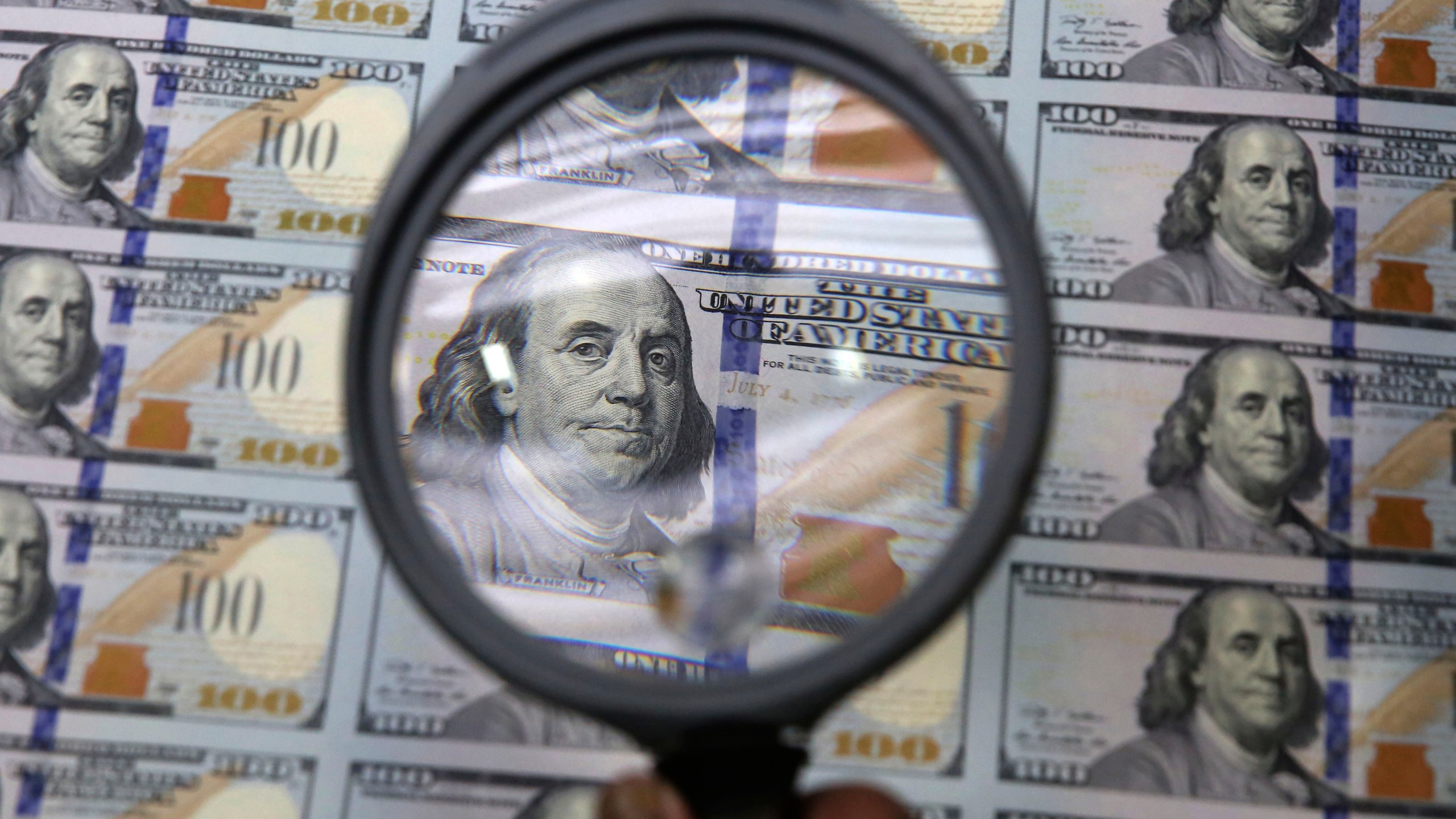 FILE - A sheet of uncut $100 bills is inspected during the printing process at the Bureau of Engraving and Printing Western Currency Facility in Fort Worth, Texas, on Sept. 24, 2013. More than $200 billion may have been stolen from two large pandemic-relief initiatives, according to a new estimates from a federal watchdog investigating federally funded programs designed to help small businesses survive the worst public health crisis in more than a hundred years. (AP Photo/LM Otero, File)