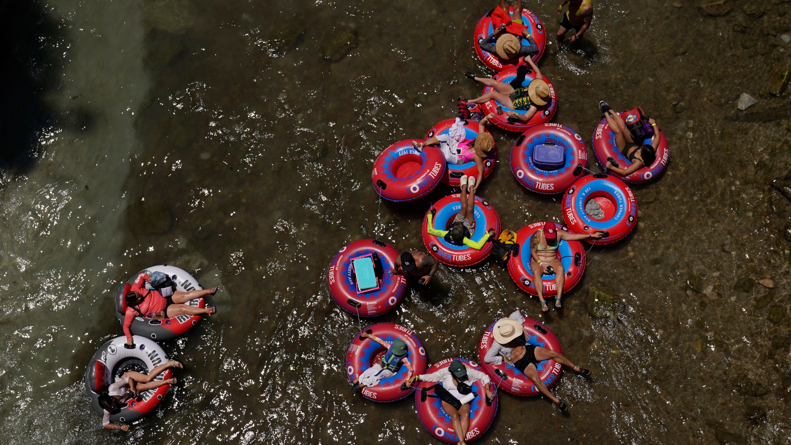 Tubers float the cool Comal River in New Braunfels, Texas, Thursday, June 29, 2023. Meteorologists say scorching temperatures brought on by a heat dome have taxed the Texas power grid and threaten to bring record highs to the state. (AP Photo/Eric Gay)