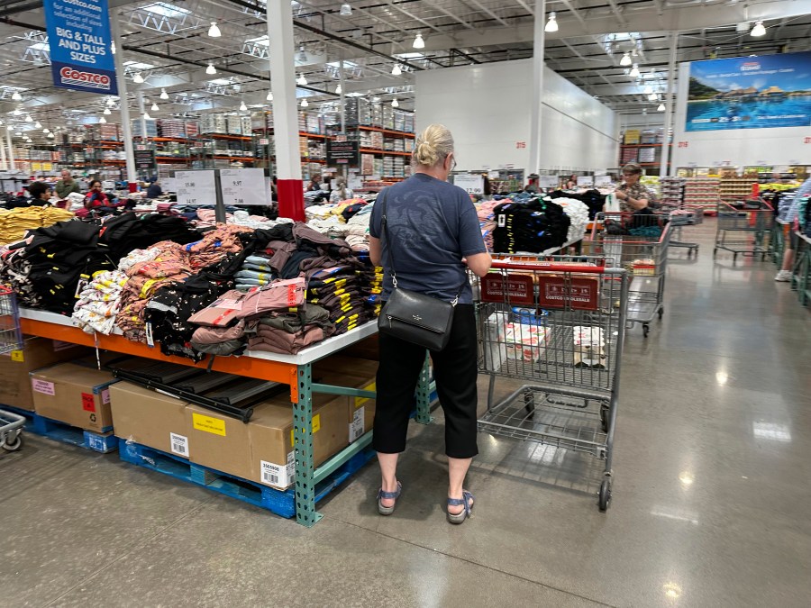 A shopper surveys stacks of clothing on a sales table in a Costco warehouse Thursday, June 22, 2023, in Colorado Springs, Colo. On Friday, the Commerce Department issues its May report on consumer spending. The report contains a measure of inflation that is closely watched by the Federal Reserve. (AP Photo/David Zalubowski)