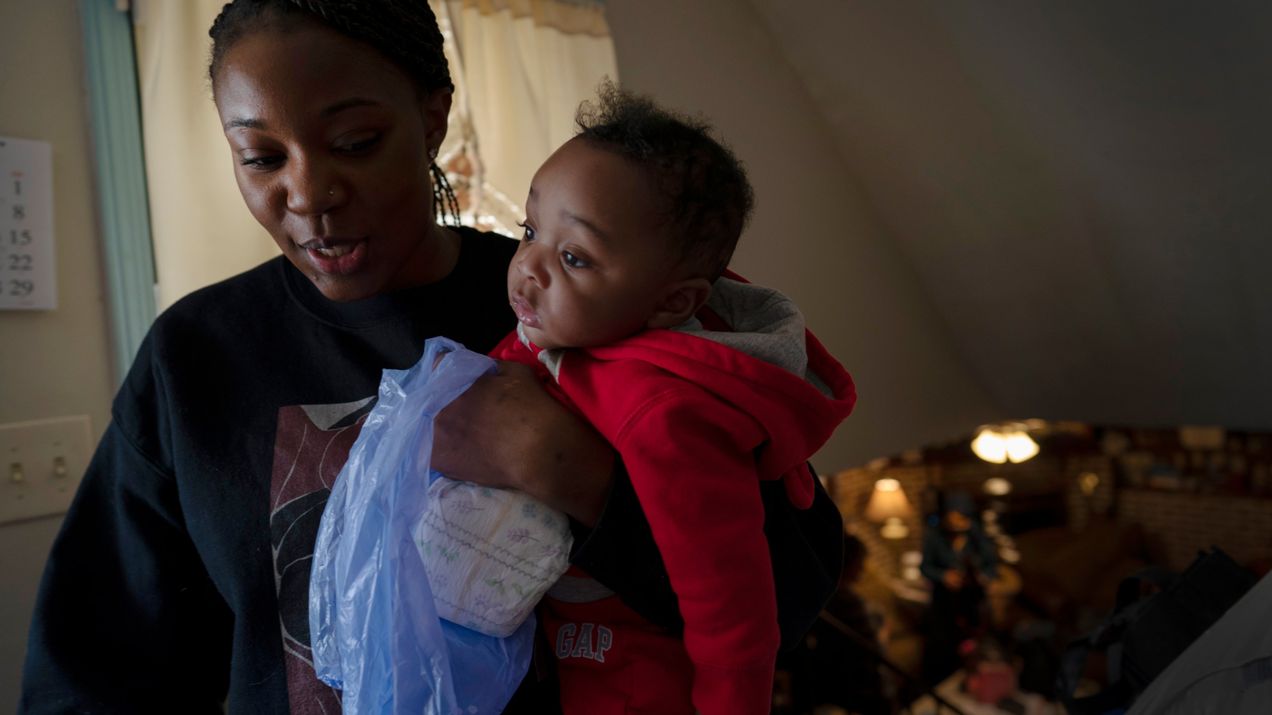 FILE - Ansonia Lyons carries her son, Adrien Lyons, as she takes him for a diaper change in Birmingham, Ala., on Saturday, Feb. 5, 2022. After two miscarriages, Ansonia became pregnant in 2020, and it was difficult. Doctors initially told her she was suffering from regular morning sickness, though she was vomiting blood. Ultimately, she was diagnosed with an excessive vomiting disorder. A study published Monday, July 3, 2023, in the Journal of the American Medical Association shows maternal mortality rates in the U.S. doubled between 1999 and 2019, that Native American and Alaskan Native populations had the largest rate increase and that, overall, Black maternal mortality rates were the highest. (AP Photo/Wong Maye-E, File)