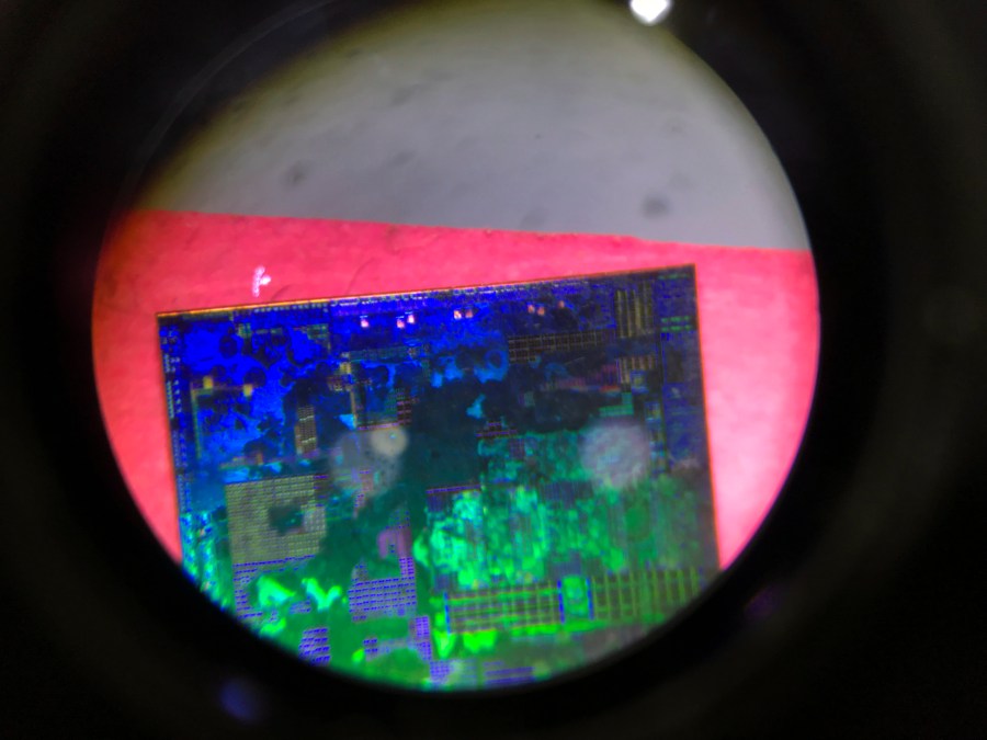 FILE - A Chinese microchip is seen through a microscope set up at the booth for the state-controlled Tsinghua Unigroup project which is aimed at driving China's semiconductor ambitions during the 21st China Beijing International High-tech Expo in Beijing, China, on May 17, 2018. China has imposed export curbs on two metals used in computer chips and solar cells, expanding a squabble with Washington over high-tech trade ahead of Treasury Secretary Janet Yellen's visit to Beijing this week. (AP Photo/Ng Han Guan, File)