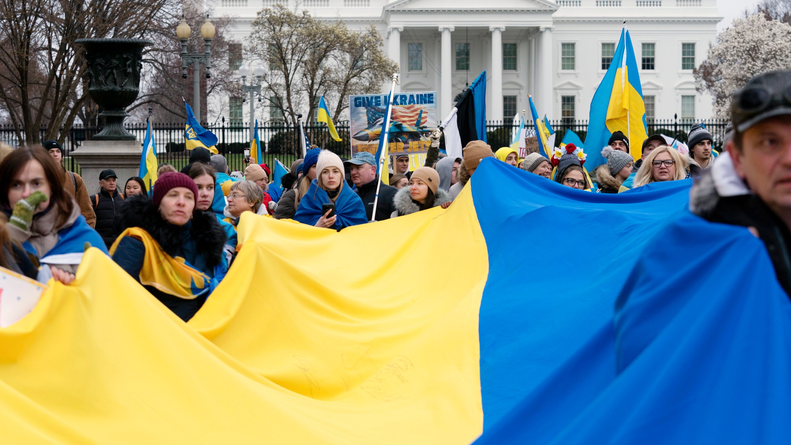 FILE - Demonstrators hold a Ukrainian flag as they march outside of the White House in support of Ukraine during a rally in Washington, Feb. 25, 2023. One of the architects of the covert U.S. strategy against the Soviets in Afghanistan has published a new memoir. In “By All Means Available,” Michael Vickers calls on President Joe Biden’s administration to increase its support for Ukraine’s resistance against Russia. (AP Photo/Jose Luis Magana, File)