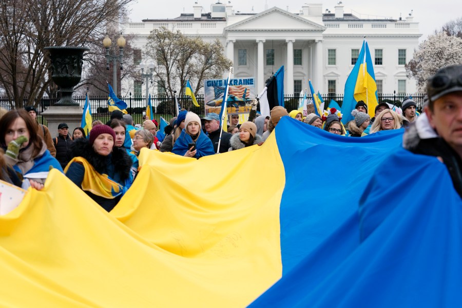 FILE - Demonstrators hold a Ukrainian flag as they march outside of the White House in support of Ukraine during a rally in Washington, Feb. 25, 2023. One of the architects of the covert U.S. strategy against the Soviets in Afghanistan has published a new memoir. In “By All Means Available,” Michael Vickers calls on President Joe Biden’s administration to increase its support for Ukraine’s resistance against Russia. (AP Photo/Jose Luis Magana, File)