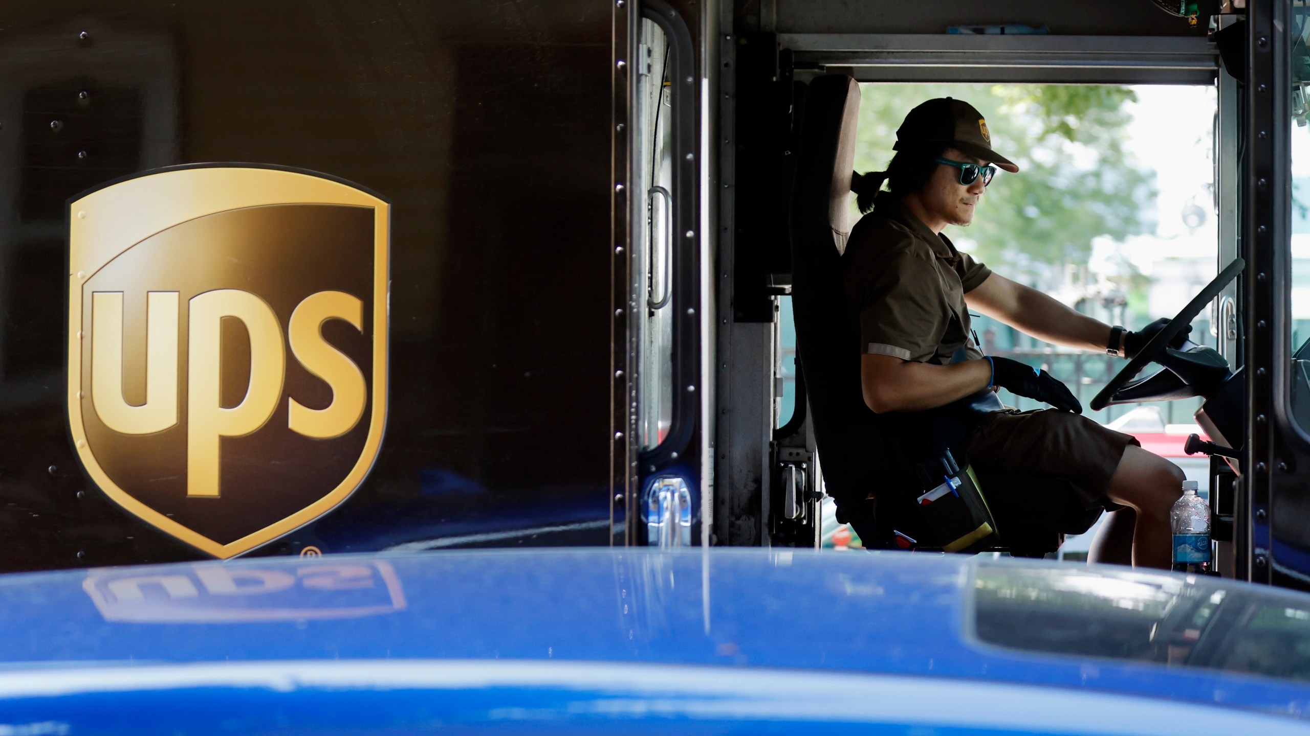 A United Parcel Service delivery driver steers his truck, Friday, June 30, 2023, in the East Boston neighborhood of Boston. Frustrated by what he called an "appalling counterproposal" earlier this week, Teamsters General President Sean O'Brien, the head of the union representing 340,000 UPS workers, said a strike now appears inevitable and gave the shipping giant a Friday deadline to improve its offer. (AP Photo/Michael Dwyer)