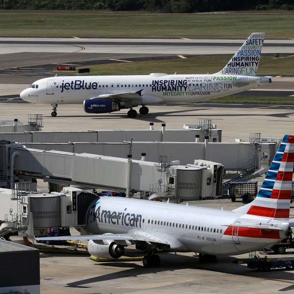 FILE - A JetBlue Airbus A320 taxis to a gate after landing, Oct. 26, 2016, as an American Airlines jet is seen parked at its gate at Tampa International Airport in Tampa, Fla. JetBlue on Wednesday, July 5, 2023, said it won't appeal a judge's ruling against its partnership with American Airlines, effectively dropping the deal in an effort to salvage its purchase of Spirit Airlines. (AP Photo/Chris O'Meara, File)