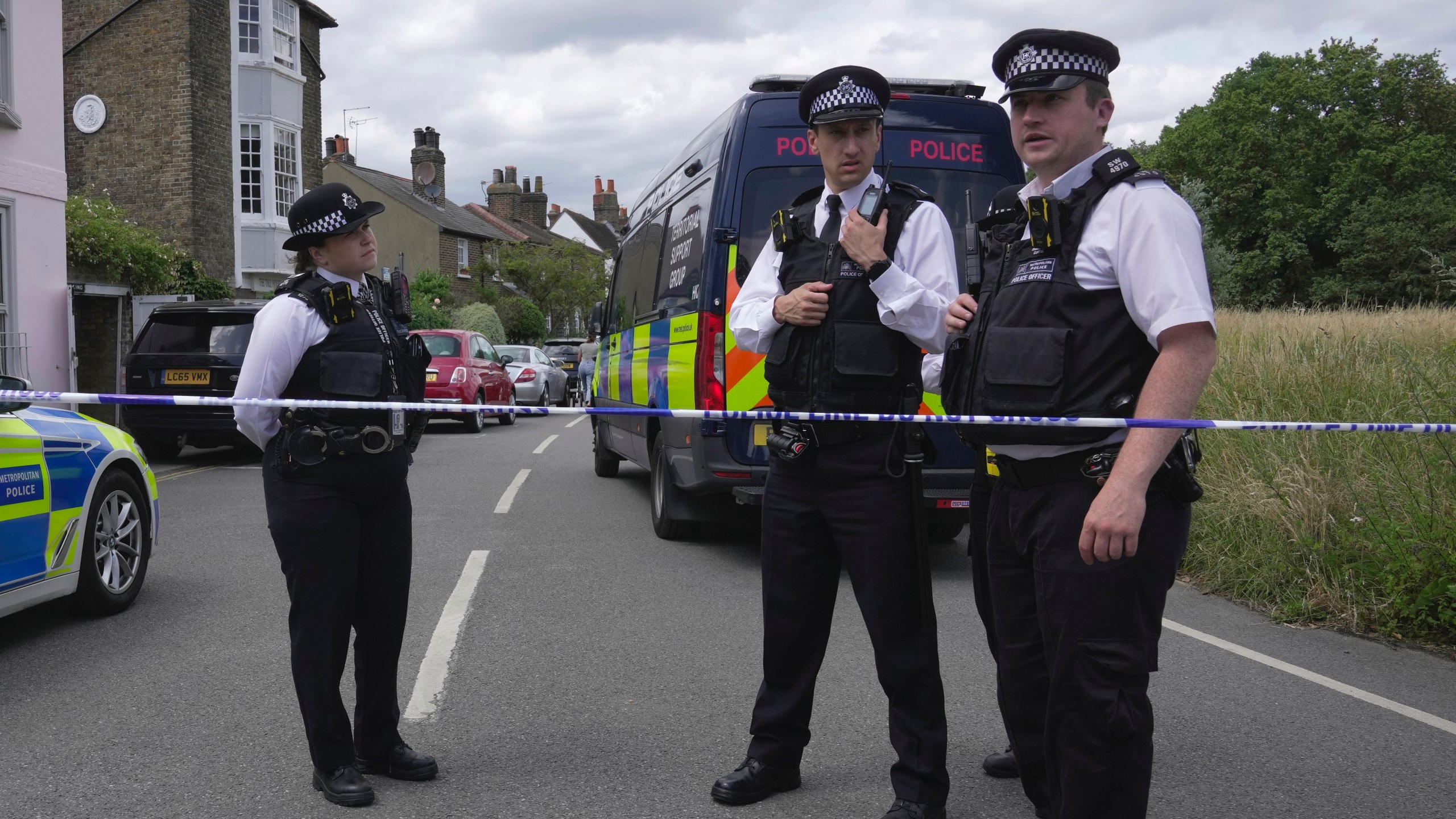 Police officers set up cordon line as a car crashed into a primary school building in Wimbledon, London, Thursday, July 6, 2023. London police say a girl died when an SUV crashed into an elementary school on a very narrow road in the Wimbledon district of southwest London. The Metropolitan Police said Thursday that there have been further injuries but did not provide details of how many. (AP Photo/Kin Cheung)