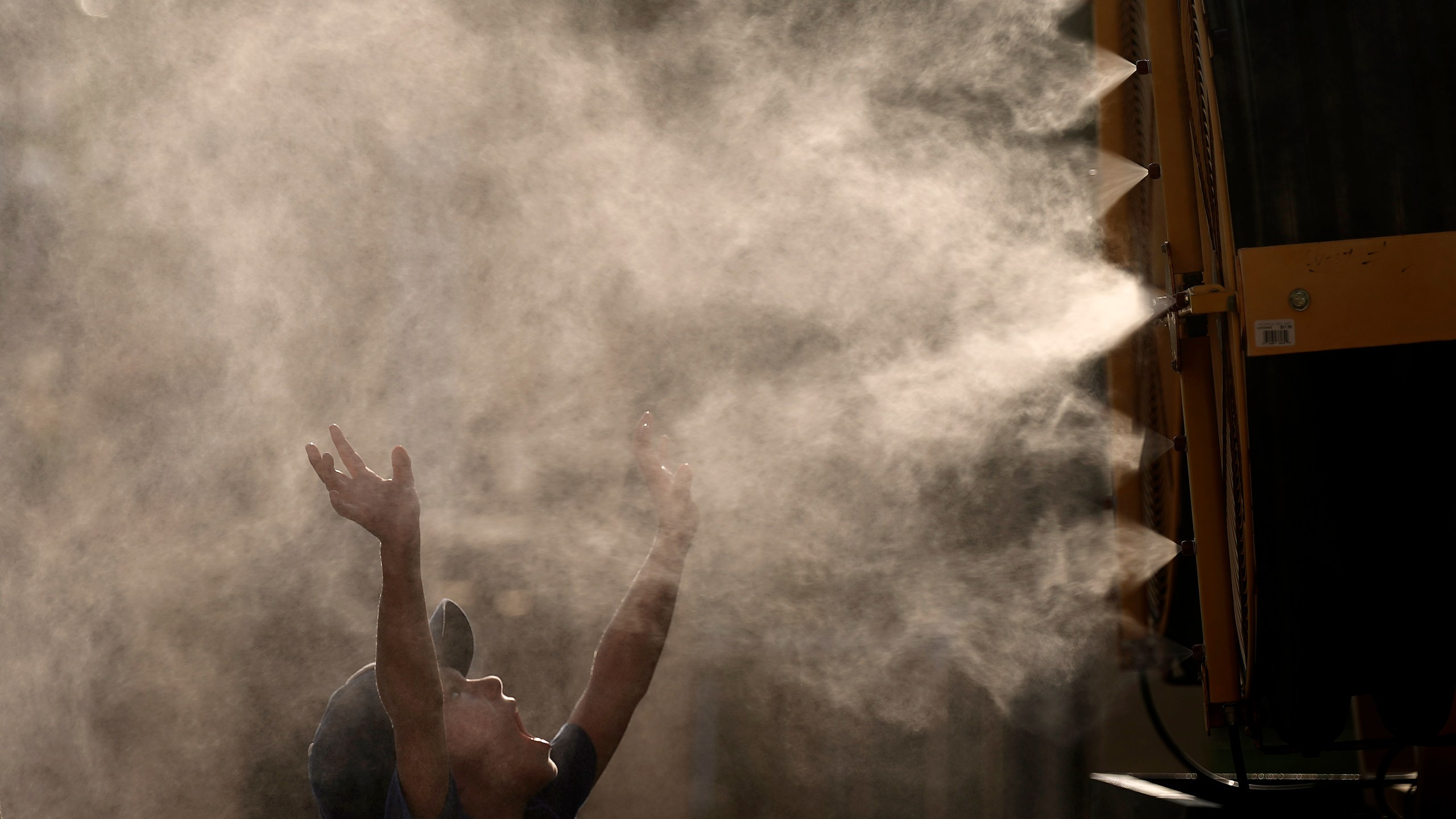 Lucas Harrington, age 7, cools off in a mister at Kauffman Stadium as temperatures approach 100 degrees fahrenheit before a baseball game between the Kansas City Royals and the Cleveland Guardians, Wednesday, June 28, 2023, in Kansas City, Mo. The entire planet sweltered for the two unofficial hottest days in human recordkeeping Monday and Tuesday, according to University of Maine scientists at the Climate Reanalyzer project. The unofficial heat records come after months of unusually hot conditions due to climate change and a strong El Nino event. (AP Photo/Charlie Riedel)