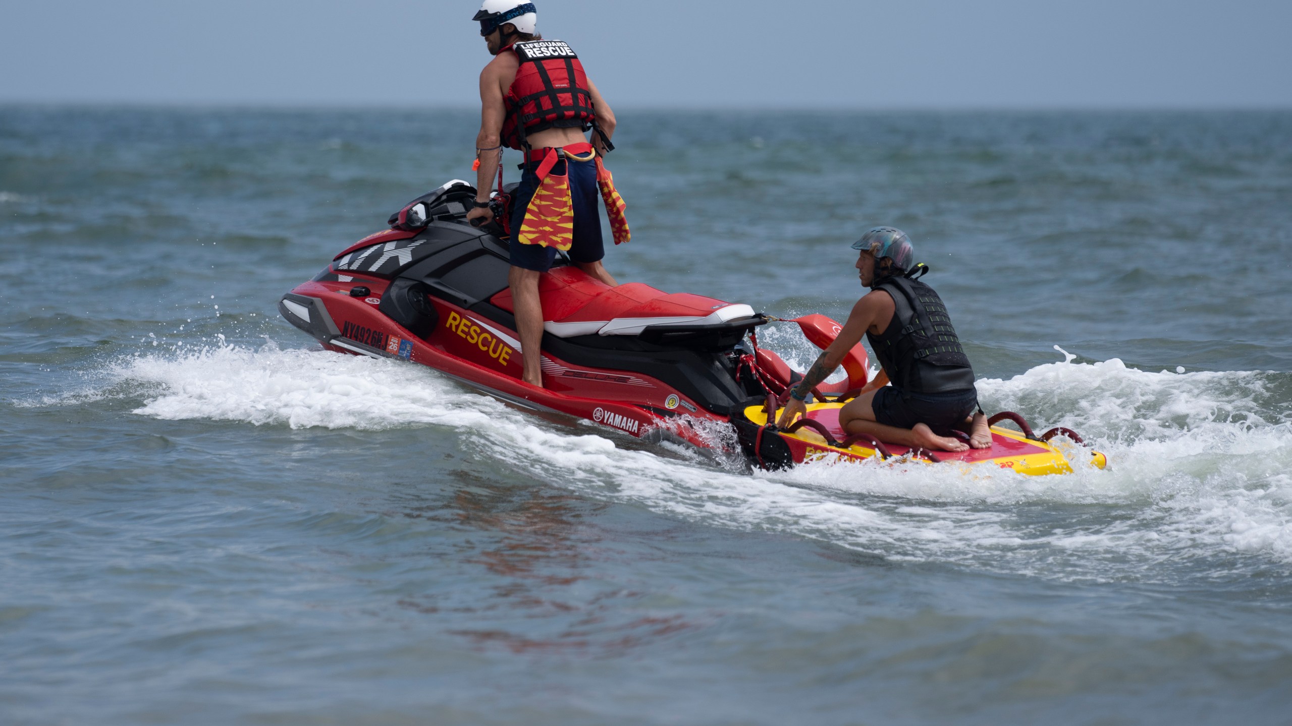 Lifeguards ride a jet ski during a shark patrol run at Jones Beach State Park, Thursday, July 6, 2023, in Wantagh, N.Y. (AP Photo/John Minchillo)