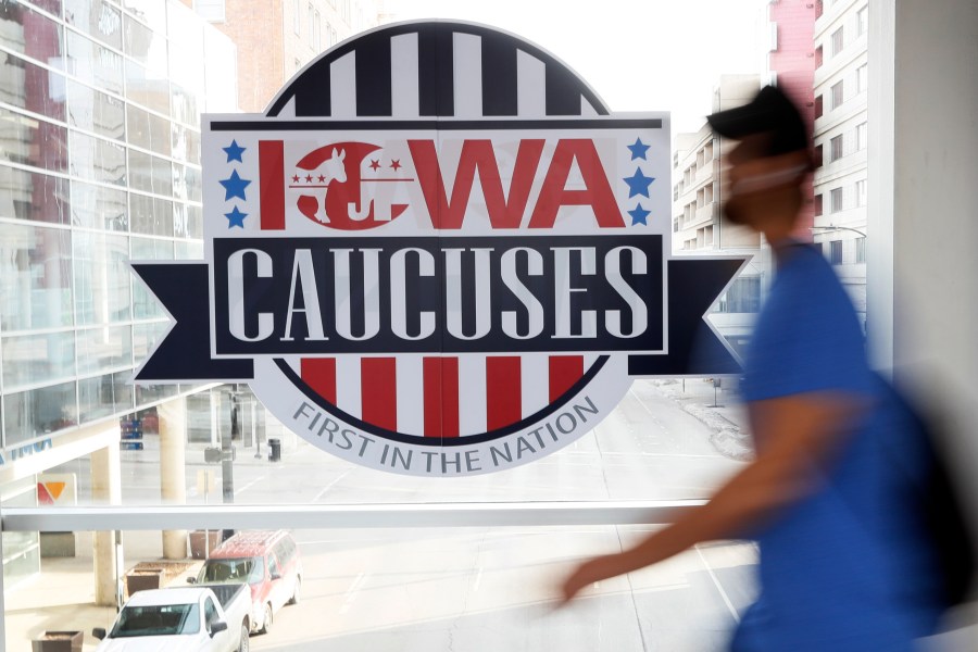 FILE - A pedestrian walks past a sign for the Iowa Caucuses on a downtown skywalk, in Des Moines, Iowa, on Feb. 4, 2020. Iowa Republicans have scheduled the party’s presidential nominating caucuses for Jan. 15, 2024, putting the first votes of the next election a little more than six months away. (AP Photo/Charlie Neibergall, File)