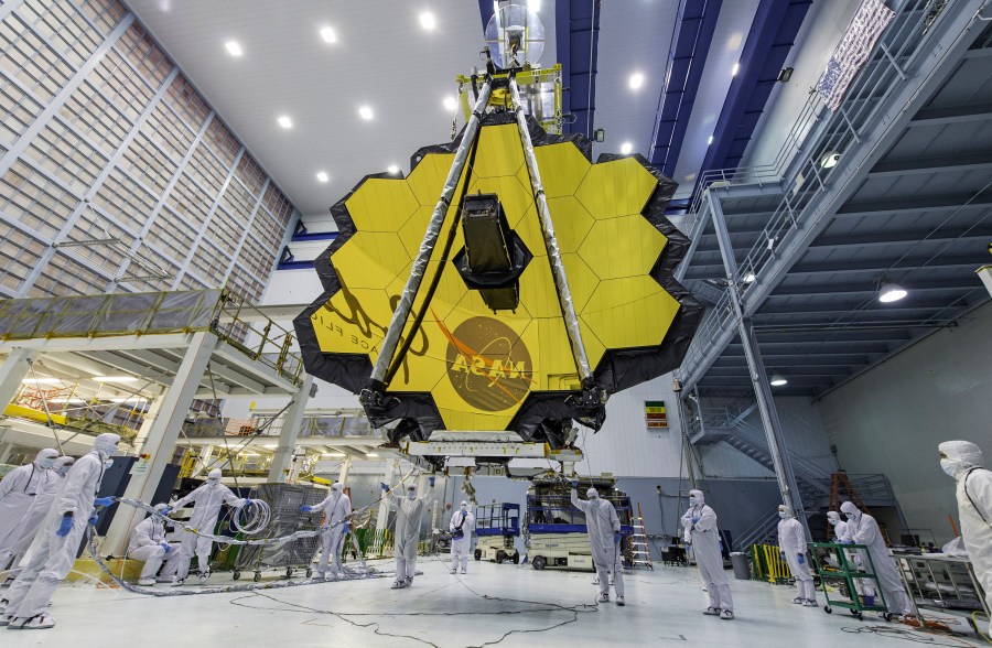 FILE - In this photo provided by NASA, technicians lift the mirror of the James Webb Space Telescope using a crane, April 13, 2017, at the Goddard Space Flight Center in Greenbelt, Md. Astronomers have discovered the most distant black hole yet using the Webb Space Telescope, but that record isn't expected to last. Webb already has spotted other black holes that appear to be even more distant, but those findings are still under review. (Laura Betz/NASA via AP, File)