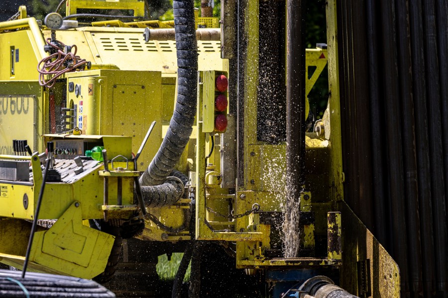 Groundwater squirts up during drilling for a geothermal heating and cooling system at a home in White Plains, N.Y., Monday, May 8, 2023. A water-filled loop installed several hundred feet deep either carries heat away from, or into the house, depending on the season. Industry experts see the technology becoming increasingly popular in the coming years. (AP Photo/Julia Nikhinson)