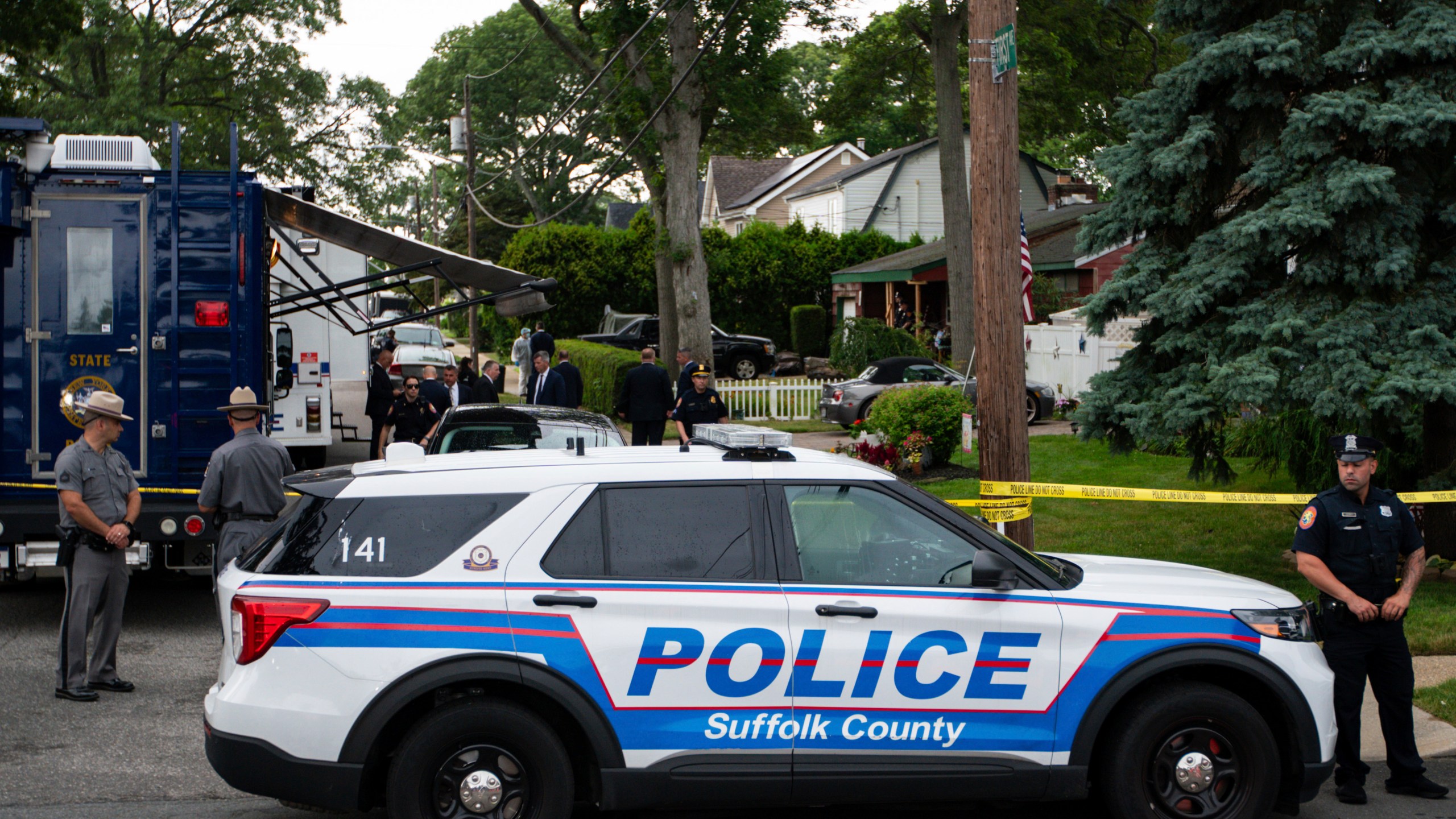 Police officers stand guard near the house where a suspect has been taken into custody on New York's Long Island in connection with a long-unsolved string of killings, known as the Gilgo Beach murders, Friday, July 14, 2023, in Massapequa Park, N.Y. (AP Photo/Eduardo Munoz Alvarez)