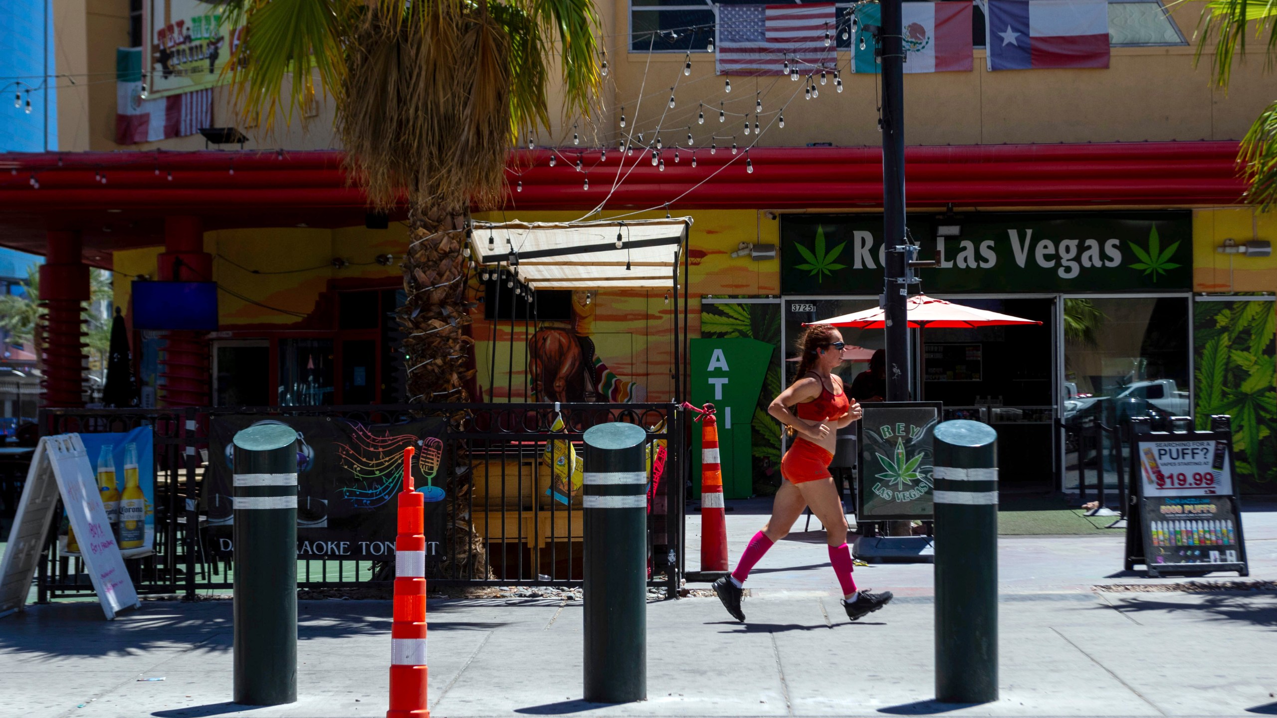 A person jogs on the Las Vegas strip during a heat advisory, Friday, July 14, 2023 in Las Vegas. Nearly a third of Americans were under extreme heat advisories, watches and warnings Friday, including in Las Vegas as a high pressure dome moves west from Texas. (AP Photo/Ty O'Neil)