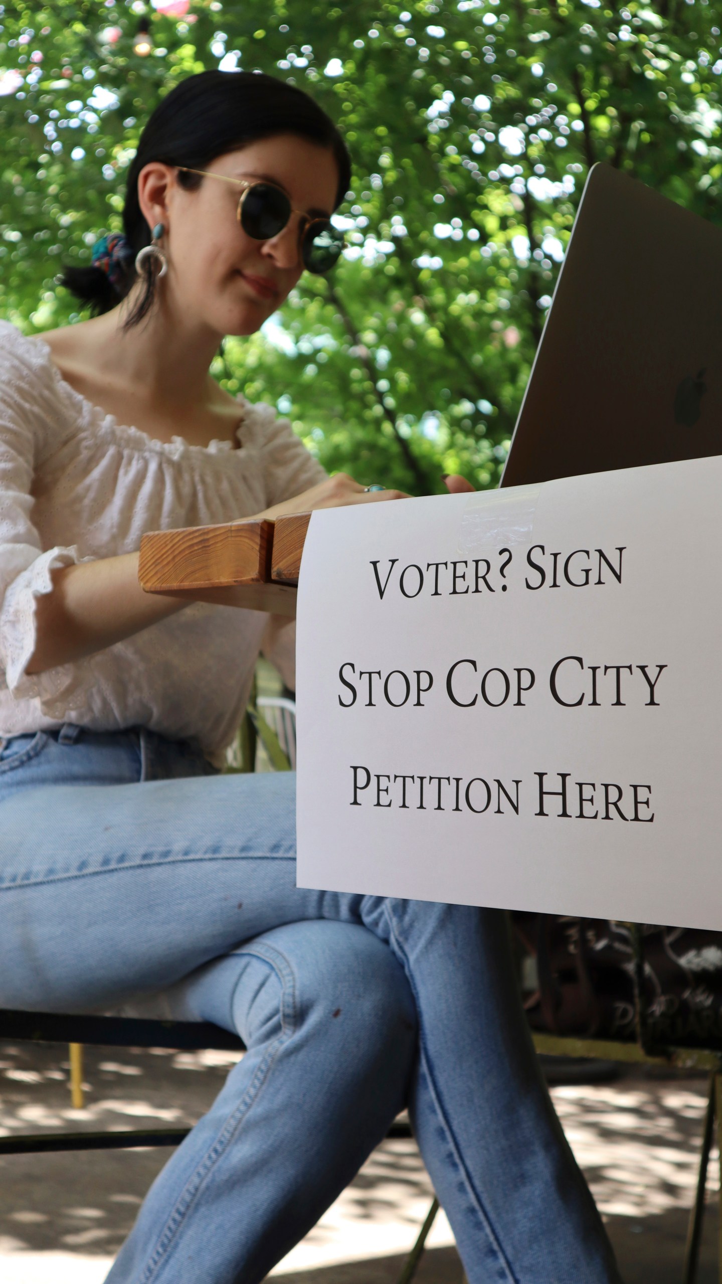 Activist Hannah Riley works on her laptop at Muchacho, a local taco restaurant, while gathering signatures from fellow voters, in Atlanta, Thursday, July 13, 2023. Organizers are trying to force a referendum that would allow voters to decide the fate of a proposed police and training center, but attorneys for the city say the petition drive is invalid. (AP Photo/R.J. Rico)