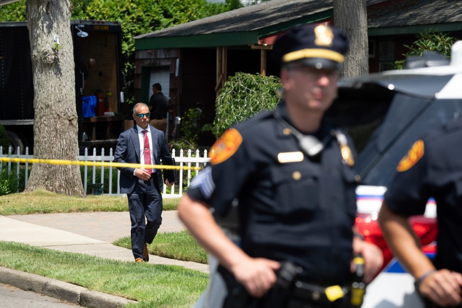 Police officers stand guard as law enforcement searches the home of Rex Heuermann, Saturday, July 15, 2023, in Massapequa Park, N.Y. Heuermann, a Long Island architect, was charged Friday, July 14, with murder in the deaths of three of the 11 victims in a long-unsolved string of killings known as the Gilgo Beach murders. (AP Photo/Jeenah Moon)