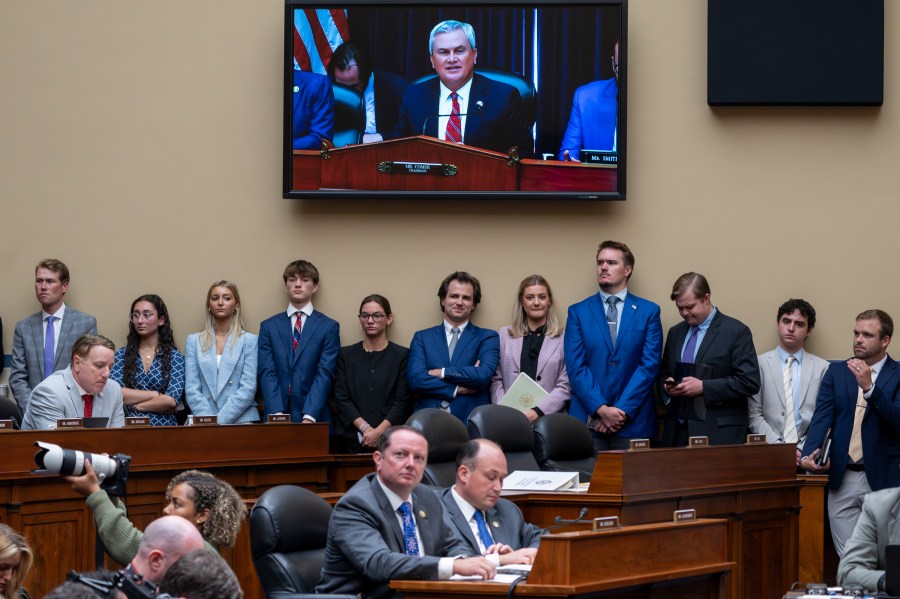 Congressional staffers stand beneath a monitor showing House Oversight and Accountability Committee Chair James Comer, R-Ky., as he charges that the Justice Department interfered with a yearslong investigation into Hunter Biden, during a hearing at the Capitol in Washington, Wednesday, July 19, 2023. (AP Photo/J. Scott Applewhite)