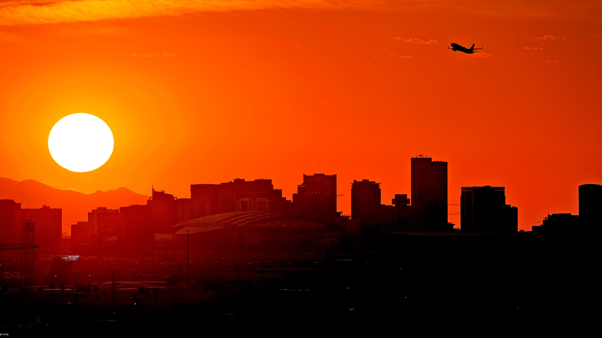 FILE - A jet takes flight from Sky Harbor International Airport as the sun sets over downtown Phoenix, Wednesday, July 12, 2023. (AP Photo/Matt York, File)